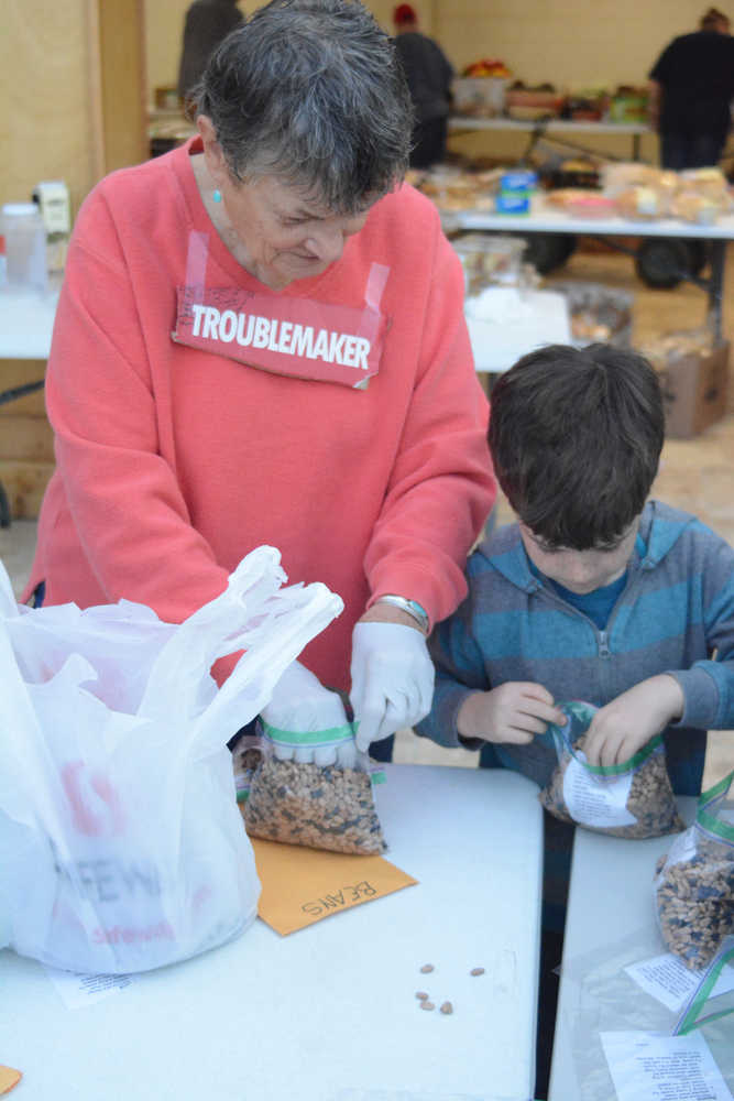 Kaye Fariday helps a student from Fireweed Academy bag food at the Homer Food Pantry on Sept. 26 at Homer United Methodist Church.