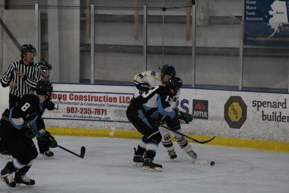 Mariner Connor Rodrick and Chugiak player Daniel Casey fight for the puck during the Mariners' Saturday afternoon game on Dec. 10 against Chugiak at Kevin Bell Arena. Andrew Beckett backs Casey up.