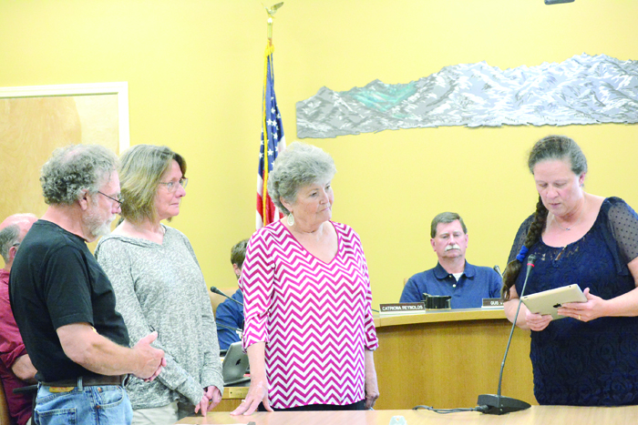 Hospice of Homer board members Michael Hawfield, Beth Graber and Pam Breckenridge, from left to right, listen as Homer Mayor Beth Wythe reads a proclamation declaring Aug. 8 Hospice of Homer Day and Aug. 2-8 Hospice of Homer Week. -Photo by Michael Armstrong, Homer News