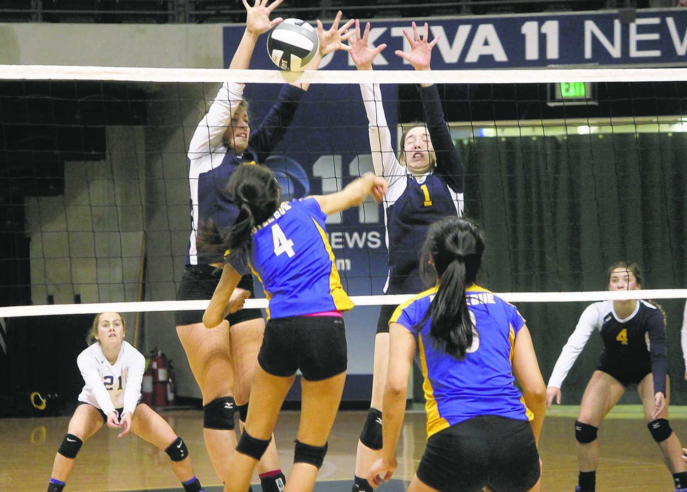 Homer seniors McKi Needham and PK Woo (1) block a shot by Kotzebue sophomore Calia Sieh (4) Friday at the Class 3A state volleyball tournament at the Alaska Airlines Arena in Anchorage.-photo by Joey Klecka, Morris News Service - Alaska