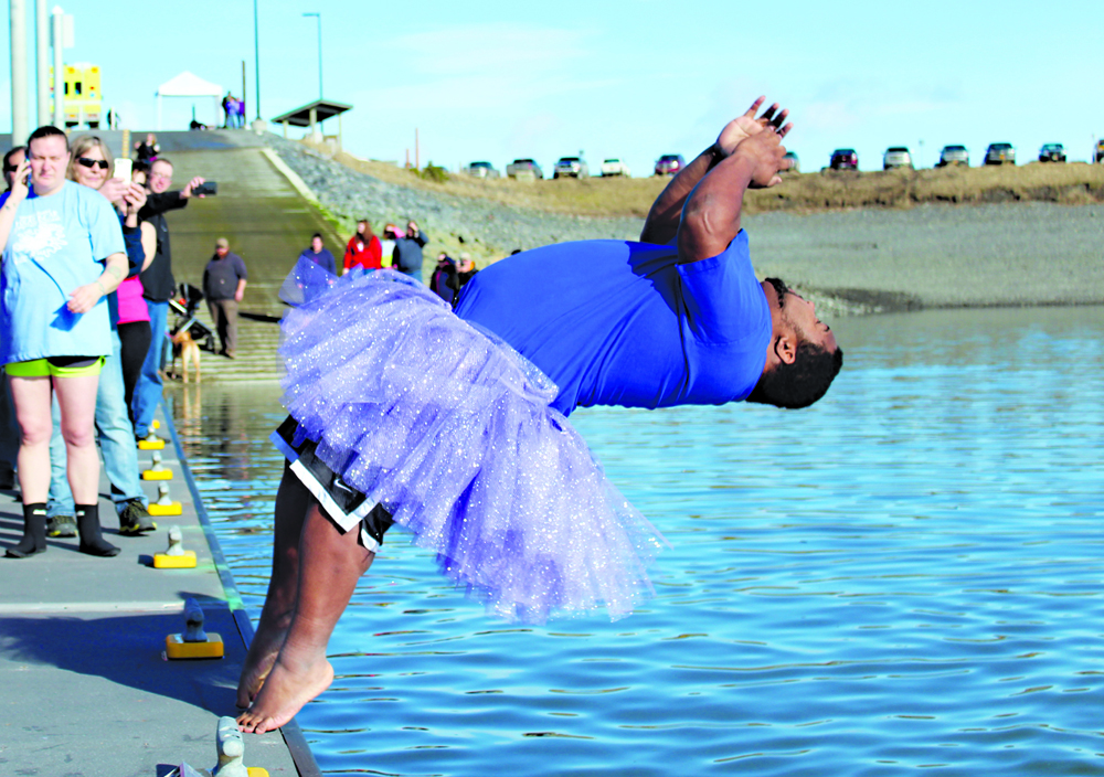 Randall White of Relay for Life in Homer backflips into the 40-degree Homer Harbor  on Saturday. Eighteen people jumped into the water during the first Homer Halibut Plunge, raising $1,300 for the American Cancer Society, White said. Those who missed out can join in on the frigid fun next year, as the group plans to make it an annual event.-Photo by Anna Frost, Homer News