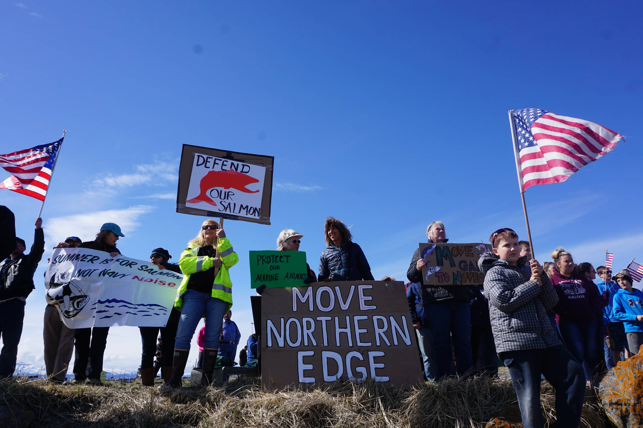 About 25 protesters with the Kachemak Bay Conservation Society and the Eyak Preservation Council greet the USS Hopper as she arrived at the Deep Water Dock on the Homer Spit about noon Saturday, April 29, 2017. A crowd of about 200 people greeted the Arleigh-Burke class destroyer on the beach as it arrived in Alaska and about 200 more greeted the ship at the Deep Water Dock. A minus 4.6 low tide at 11:37 a.m. and the wrong dock face prevented Hopper from docking at the Deep Water Dock as planned, and she was to attempt docking later in the afternoon. (Photo by Michael Armstrong/Homer News)