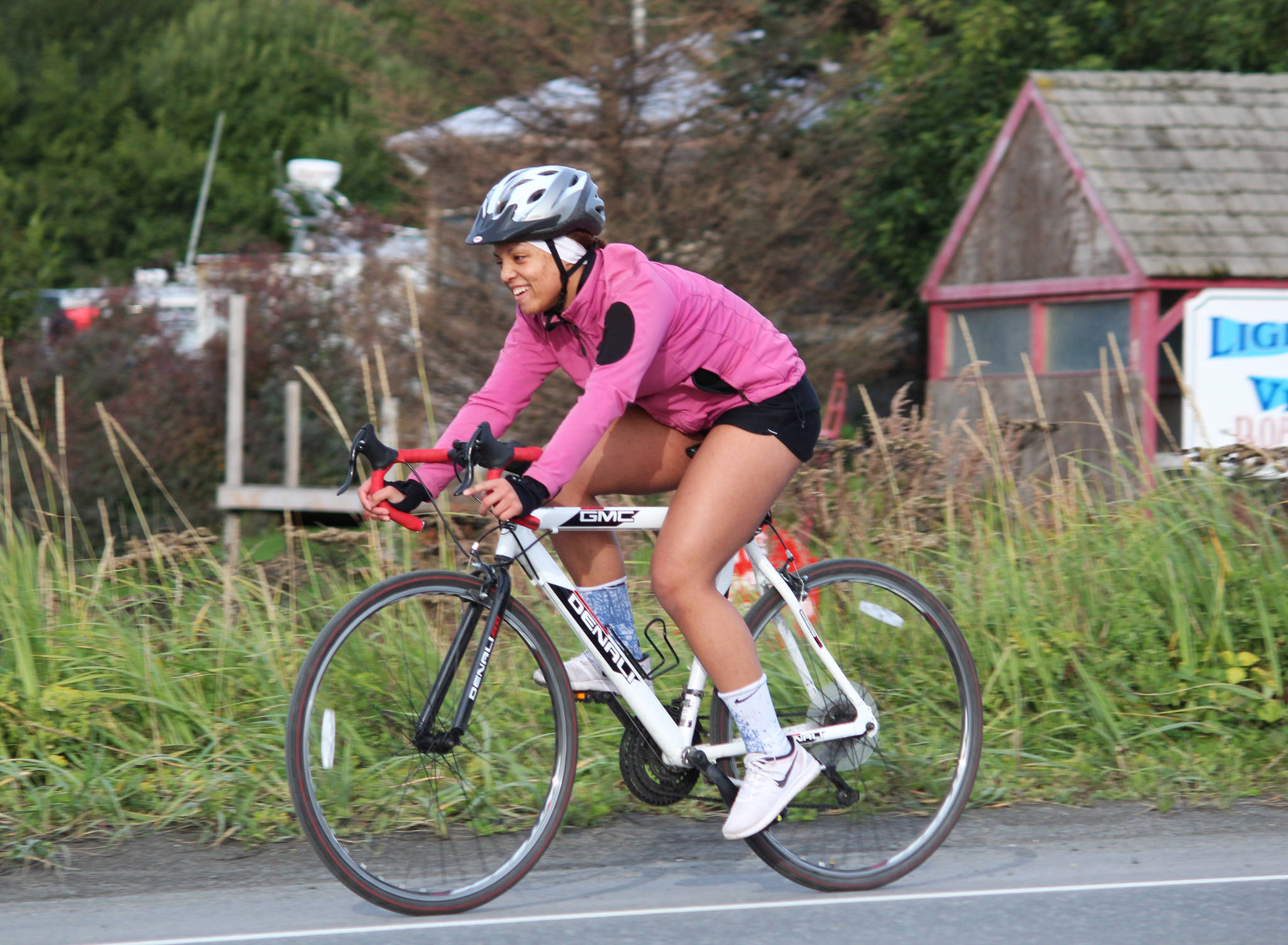 Homer Mariners swimmer Alia Bales bikes down onto the Homer Spit during the second leg of the Homer Mariner Triathlon on Saturday, Sept. 2, 2017 in Homer, Alaska. She tied for fourth in her age group with another member of the swim team, Adeline Berry. (Photo by Megan Pacer/Homer News)