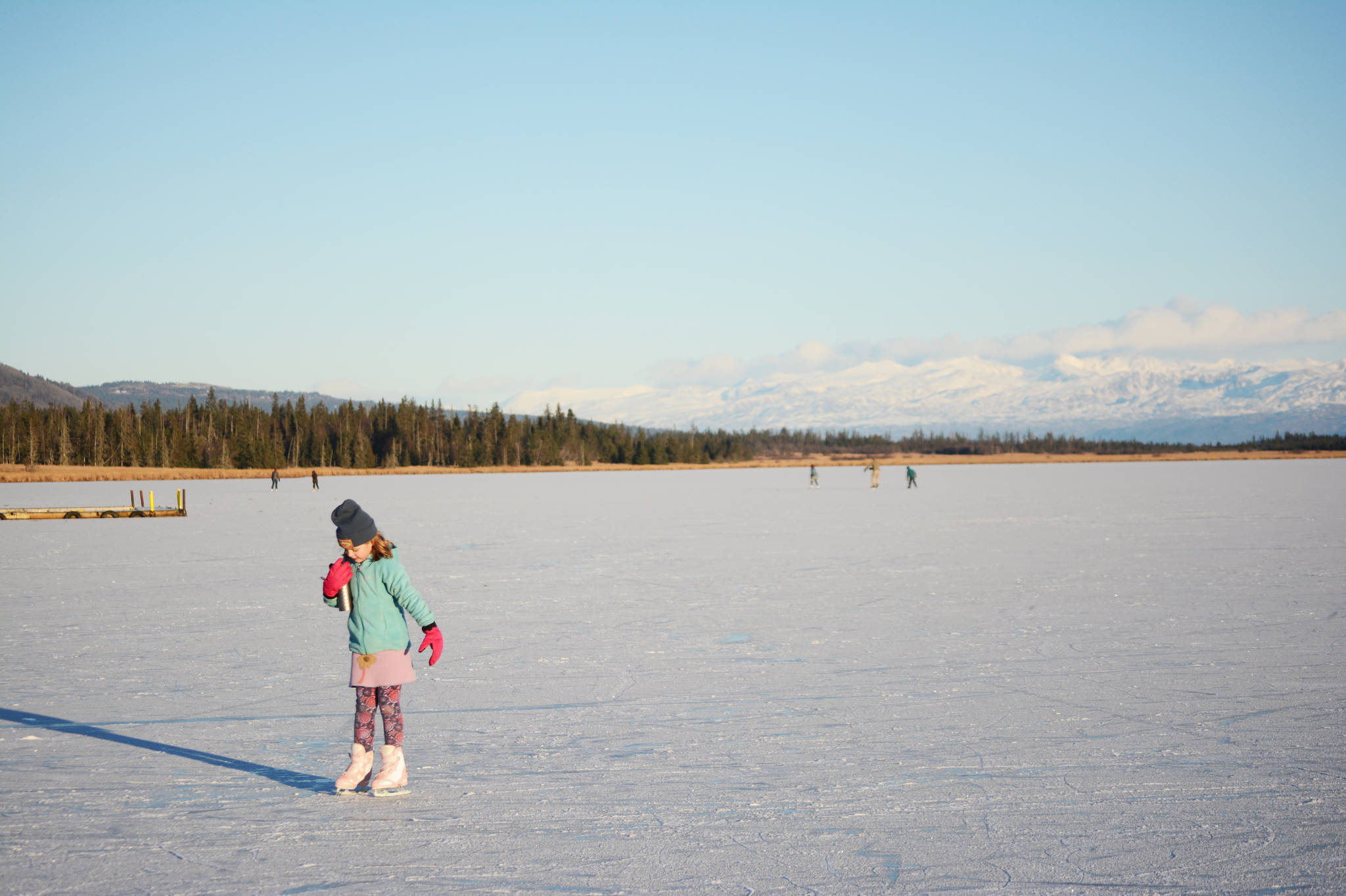 Pinky Sarber skates on Beluga Lake last Friday afternoon, Nov. 17, 2017 in Homer, Alaska. With clear and cold weather, the lake has frozen enough to support ice skating. A slight dusting of snow last Thursday didn’t affect skating. (Photo by Michael Armstrong, Homer News)