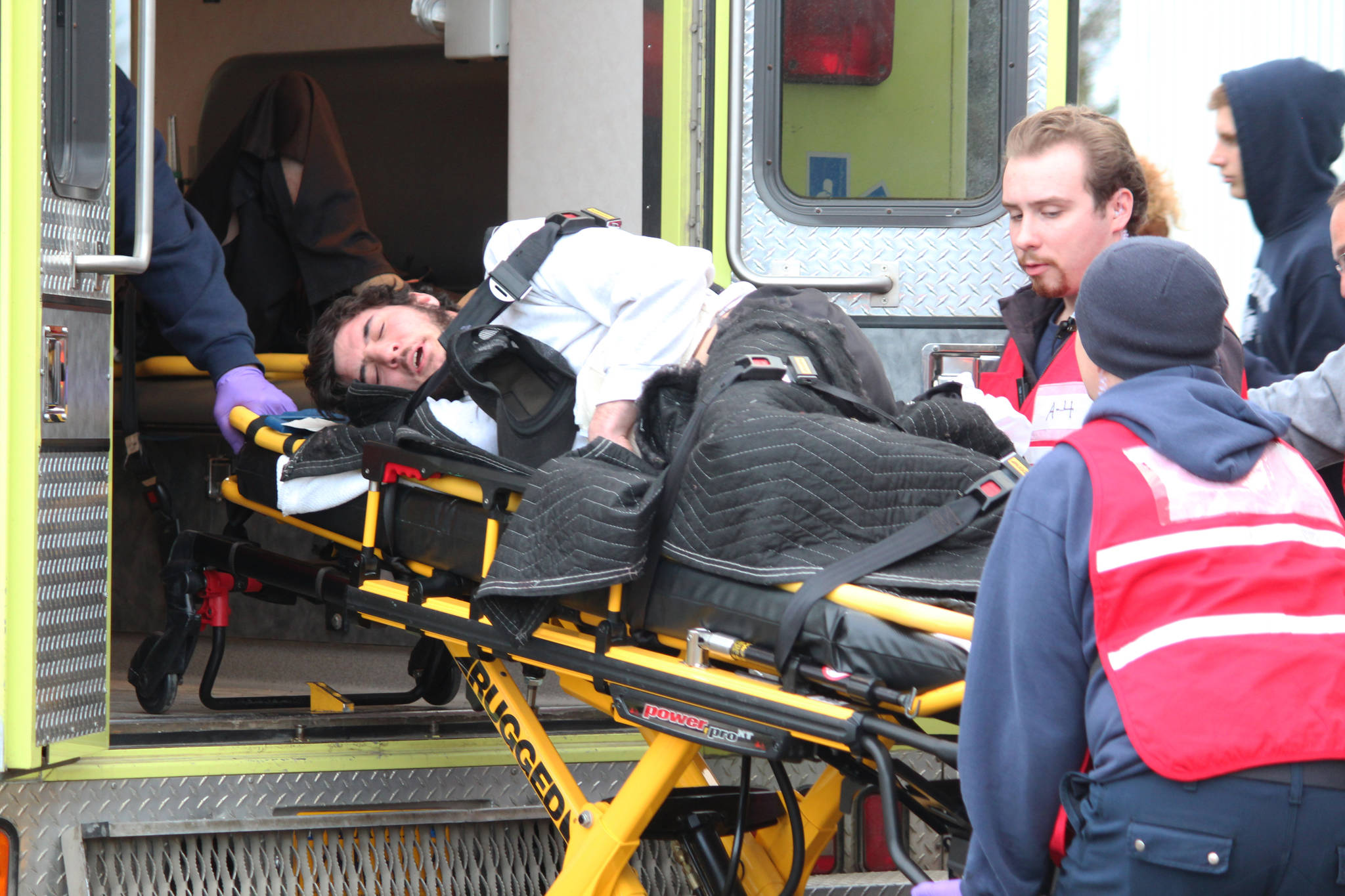 First responders load a volunteer acting as an injured patient into an ambulance Friday, Jan. 12, 2018 during an emergency exercise held at the HERC building in Homer, Alaska. (Photo by Megan Pacer/Homer News)