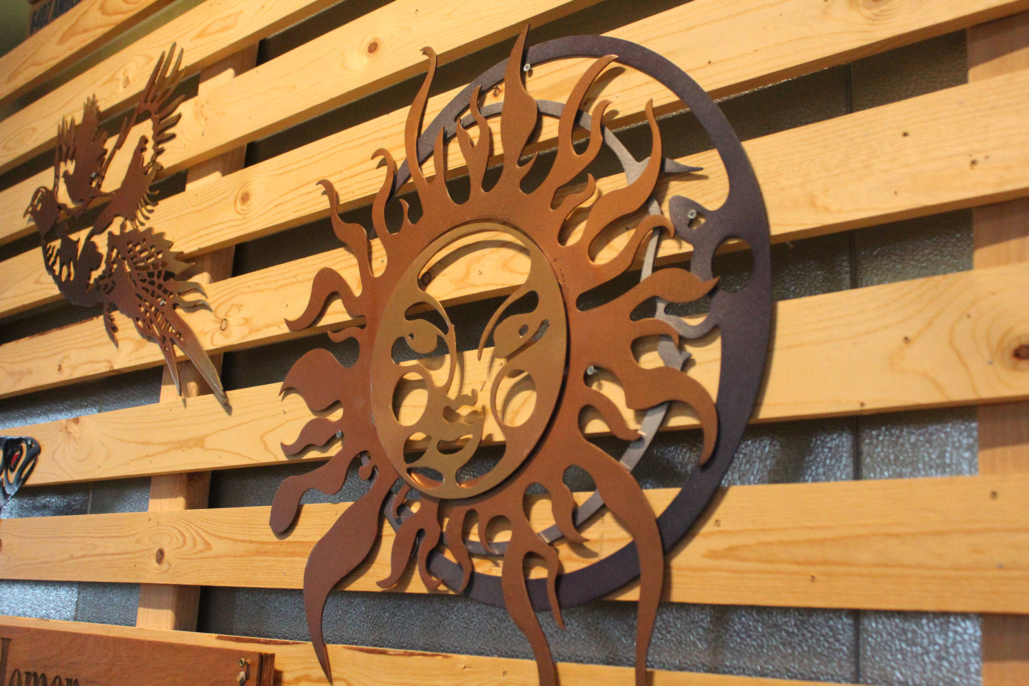 A metal sculpture depicting a sun and moon hands along with several other creations during a First Friday art show Friday, March 2, 2018 at Grace Ridge Brewery in Homer, Alaska. All the art on display during the show was created by students in Homer High School’s Computer Aided Drafting and Computer Aided Manufacturing program. (Photo by Megan Pacer/Homer News)