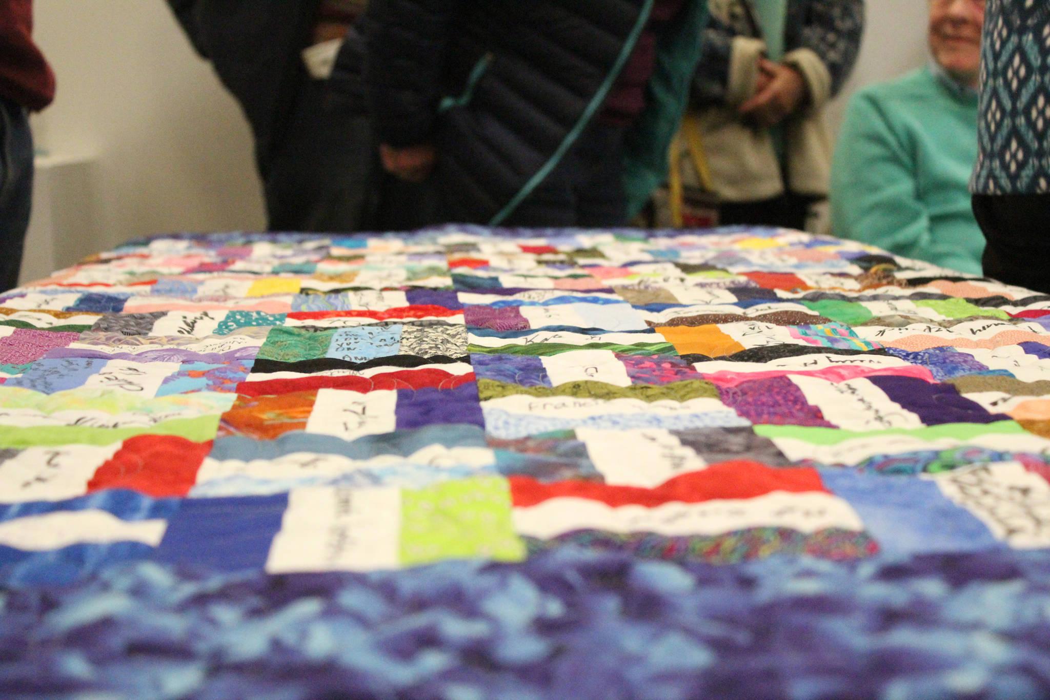 A quilt signed with well wishes lies on a table during a surprise retirement party for Darlene Hilderbrand on Sunday, March 18, 2018 at the Homer Council on the Arts in Homer, Alaska. Hilderbrand worked at Hospice of Homer for 19 years. (Photo by Megan Pacer/Homer News)