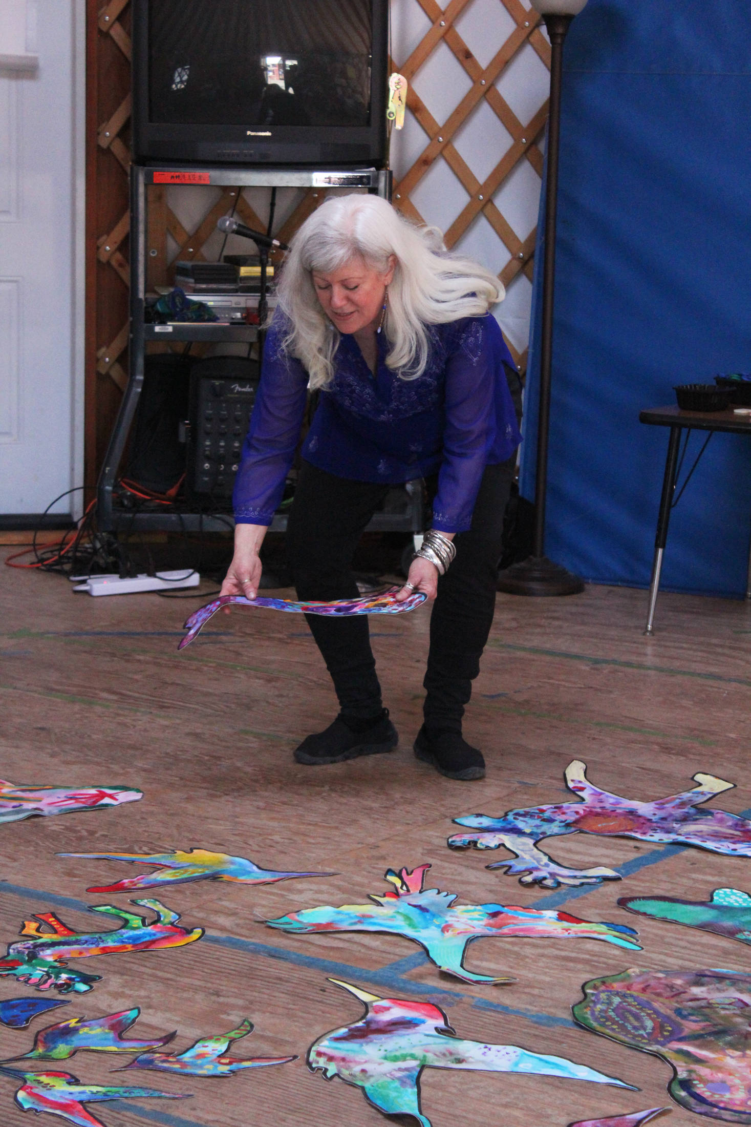 Artist Ann Margaret Wimmerstedt demonstrates the painting techniques she passed on to students at Little Fireweed Academy during an art presentation and discussion Friday, April 13, 2018 at the school in Homer. Through her stay with the students as the resident artist of the Artists in Schools program, Wimmerstedt helped the kids make a mural out of animals painted on canvas. (Photo by Megan Pacer/Homer News)