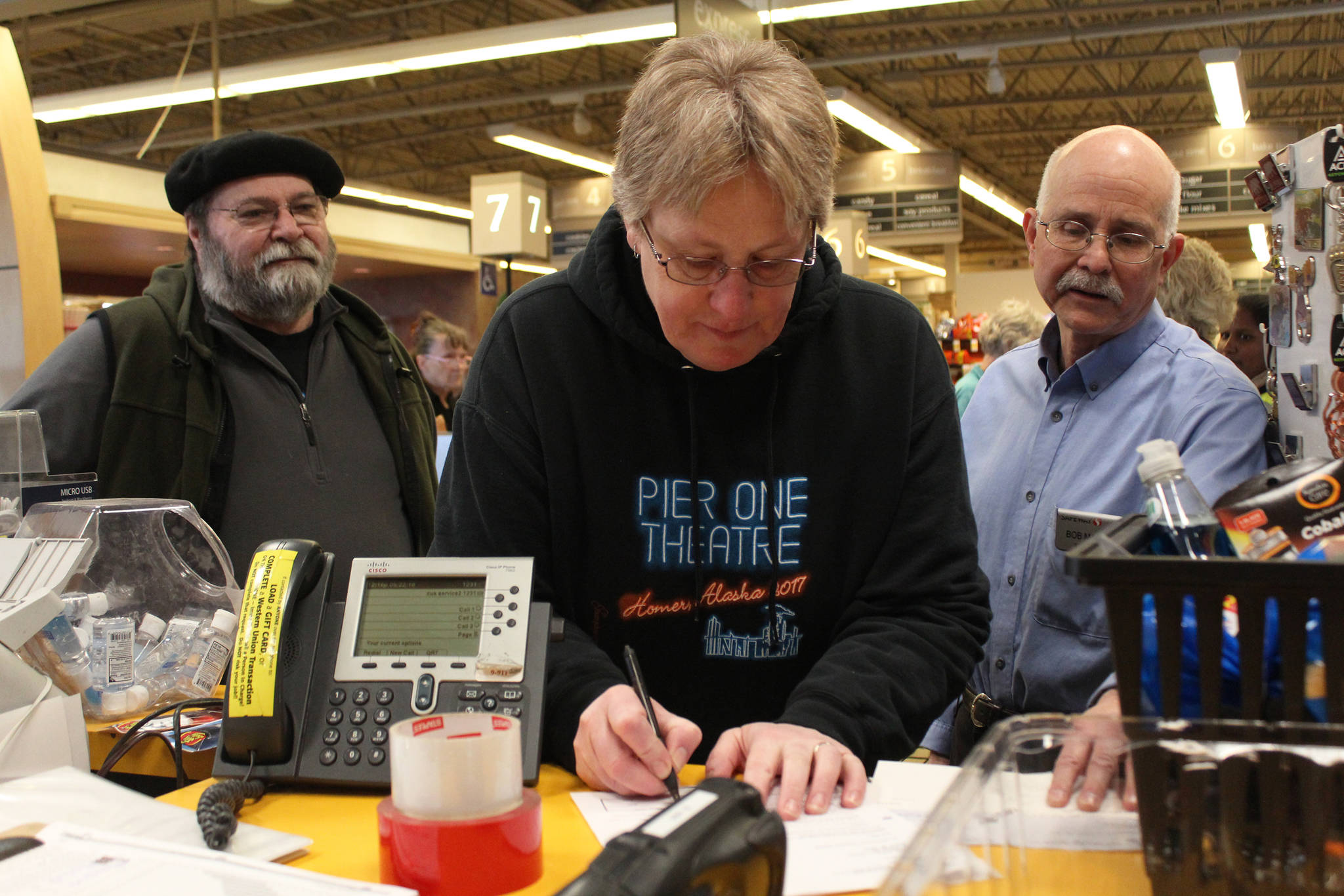 Laura Norton signs a document allowing her to take posession of a roughly $20,000 check, which she won through the Safeway Monopoly Game, during a presentation Tuesday, May 22, 2018 at Safeway in Homer, Alaska. (Photo by Megan Pacer/Homer News)