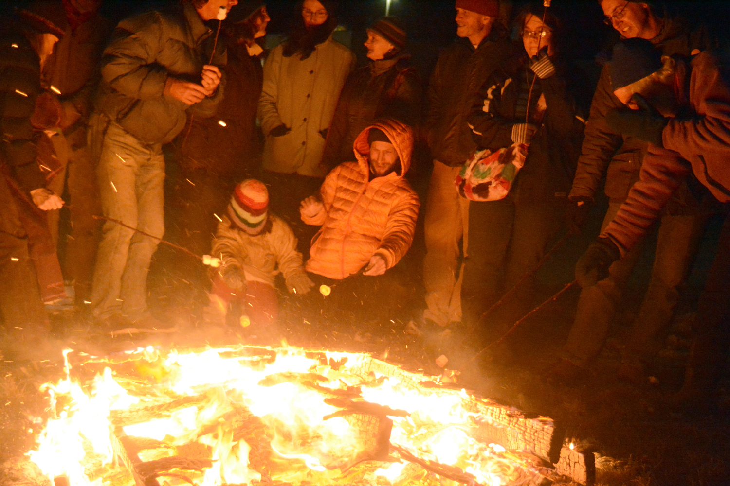 Children and adults roast marshmallows and stand around a bonfire at the kickoff for the Big Read last Friday at the Homer Public Library parking lot. Ray Bradbury’s dystopian science fiction novel about firemen who burn books, “Fahrenheit 451,” is the featured novel. -Photo by Michael Armstrong, Homer News