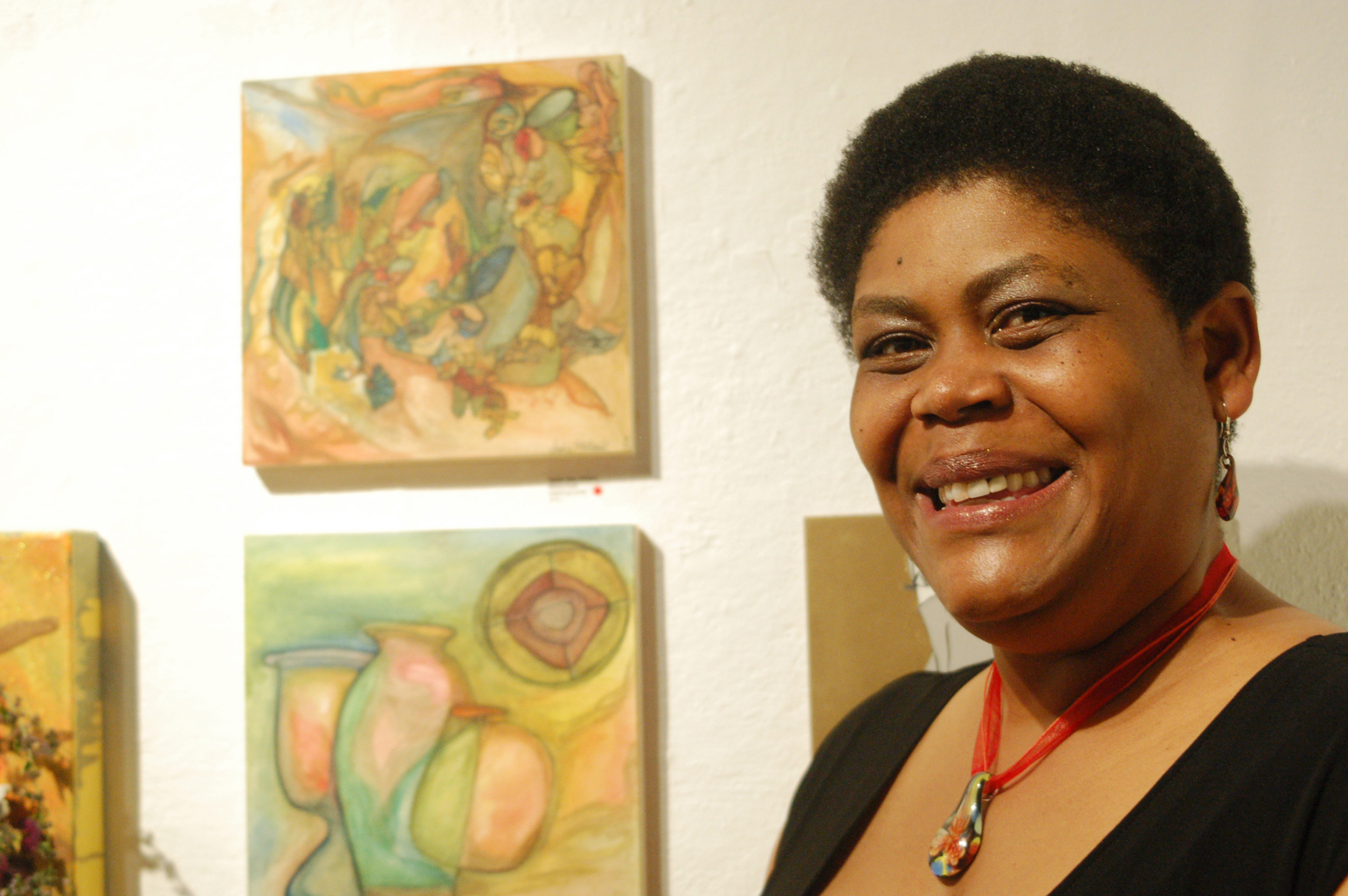 Sadie Mae Millard stands by her three paintings at the opening of the Bunnell Street Arts Center 10x10 show last Friday. Millard painted the works before and after major surgery. -Photo by Michael Armstrong, Homer News