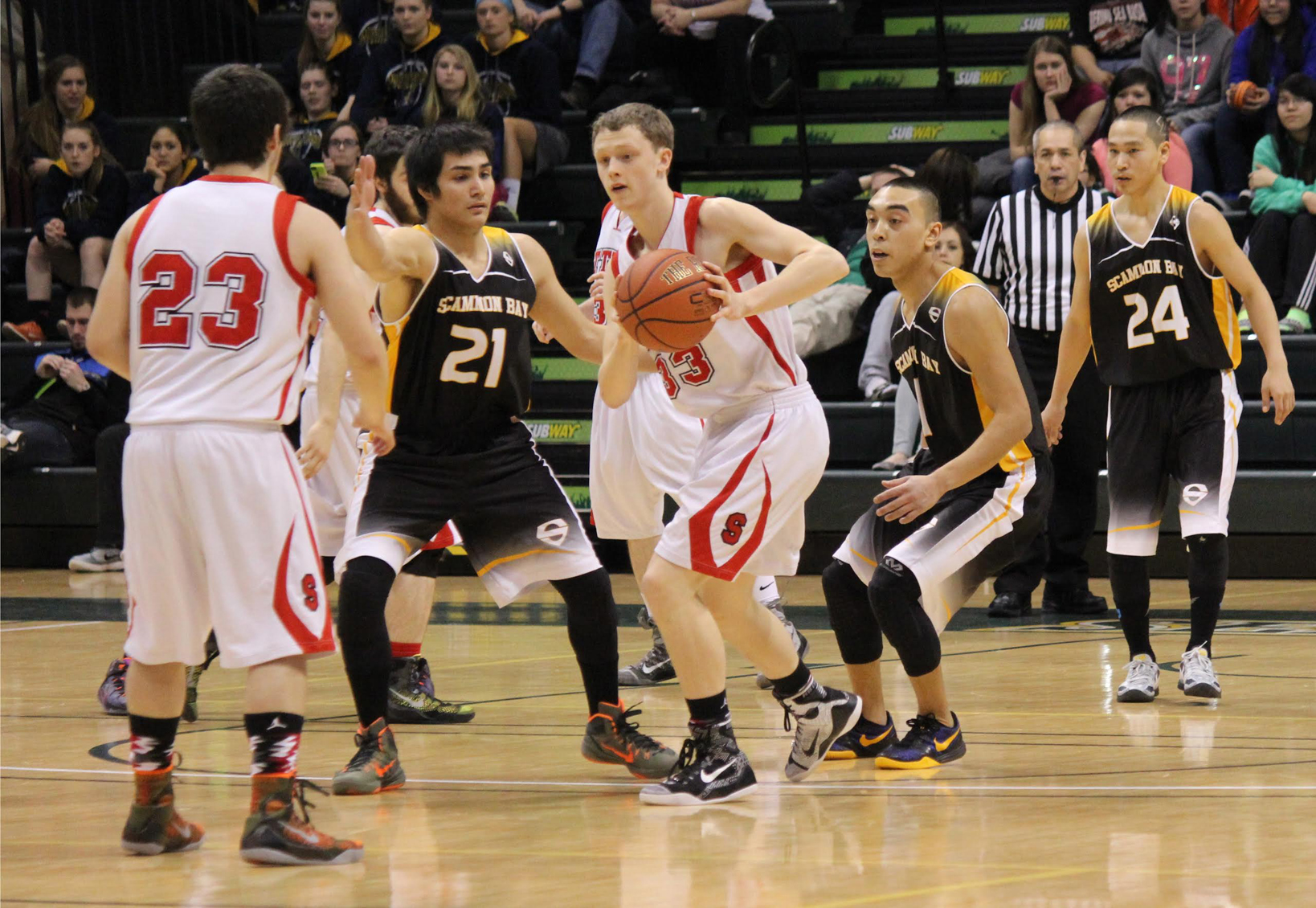 Seldovia’s Dylan Waterbury, 23, and Aidan Philpot, 33, keep the ball away from Scammon Bay during State championship play in Anchorage, March 18. More photos can be found at HomerNews.com.-Photo by McKibben Jackinsky, Homer News