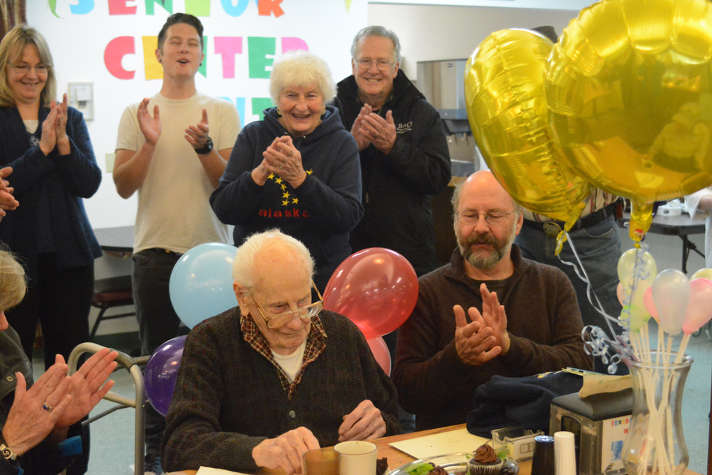 Wendell Stout, center, is applauded at the Homer Senior Center at a celebration of his 100th birthday on Sept. 28. Stout turned 100 on Sept. 27. His youngest son, Mark, 59, is at right.-Photo by Michael Armstrong, Homer News