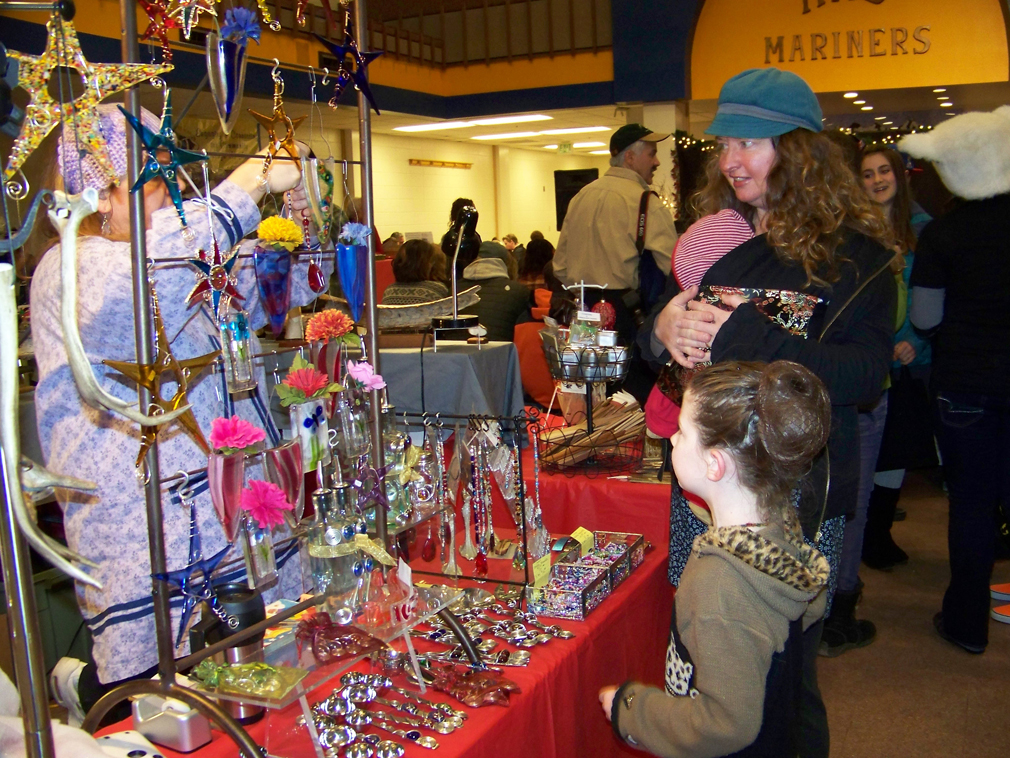 Maggie Mae Gaylord, center, examines items displayed by Rowen Mulvey at the 2012 Nutcracker Faire’s Fireweed Gallery booth. Shopping with Maggie Mae are her mother, Allison, and baby brother, Declan.Musicians Lindianna Sarno and Carol Comfort entertain at the 2012 Nutcracker Faire.-File Photos