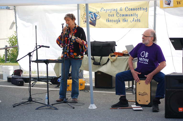 Betsy Scott sings while Eddie Wood plays the cajon at the Homer Council on the Arts Street Faire last Saturday.-Photo by Michael Armstrong, Homer News