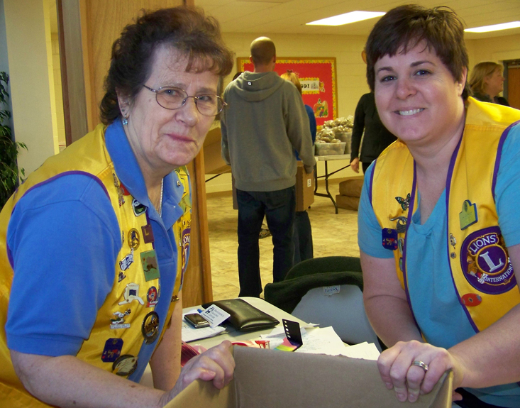 Fran Van Sandt, left, and Amy Shumaker organize the packing of food boxes for the 2012 Lions Club Thanksgiving Basket Program. -Homer News file photo