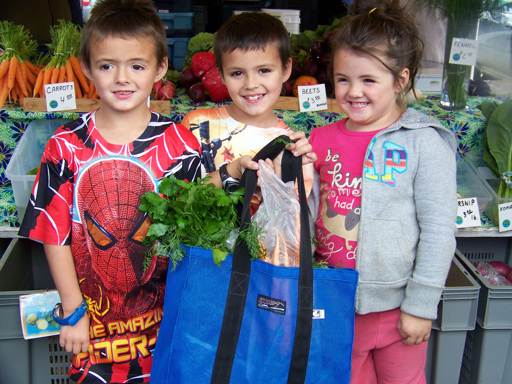 Shead, Trace and Arrienna Fleenor load up on fresh veggies at Saturday’s Homer Farmers’ Market.-Photo by McKibben Jackinsky, Homer News