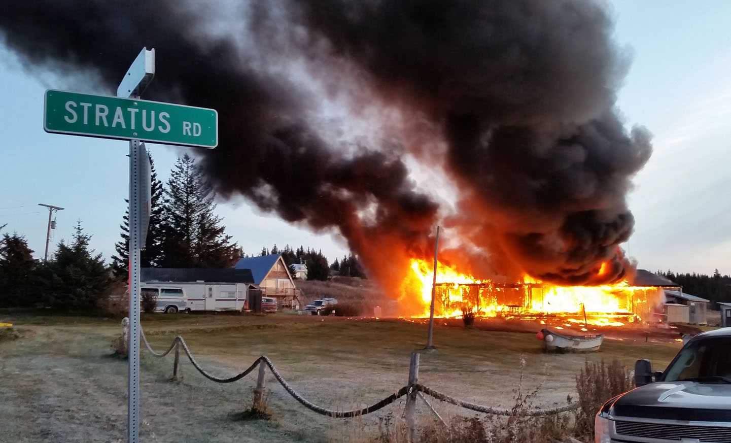 Flames engulf a house near the intersection of Diamond Ridge Road and Stratus Road Wednesday morning. One individual was injured by the fire. -Photo by Chad Jones