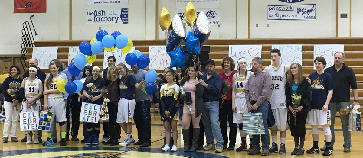 Mariner girls and boys basketball and cheerleader seniors Desiree Cleary, Aurora Waclawski, Samantha Draves, Kayla Stafford, Jadzia Martin, Breeanna Torsen, Madison Akers, Johann Kallelid and Grace Kann, left to right, pose with their parents in between the boys and girls varsity basketball games on Feb. 26. All the seniors were recognized for their athletic careers at senior night and received gifts from their teams.-Photo by Anna Frost, Homer News