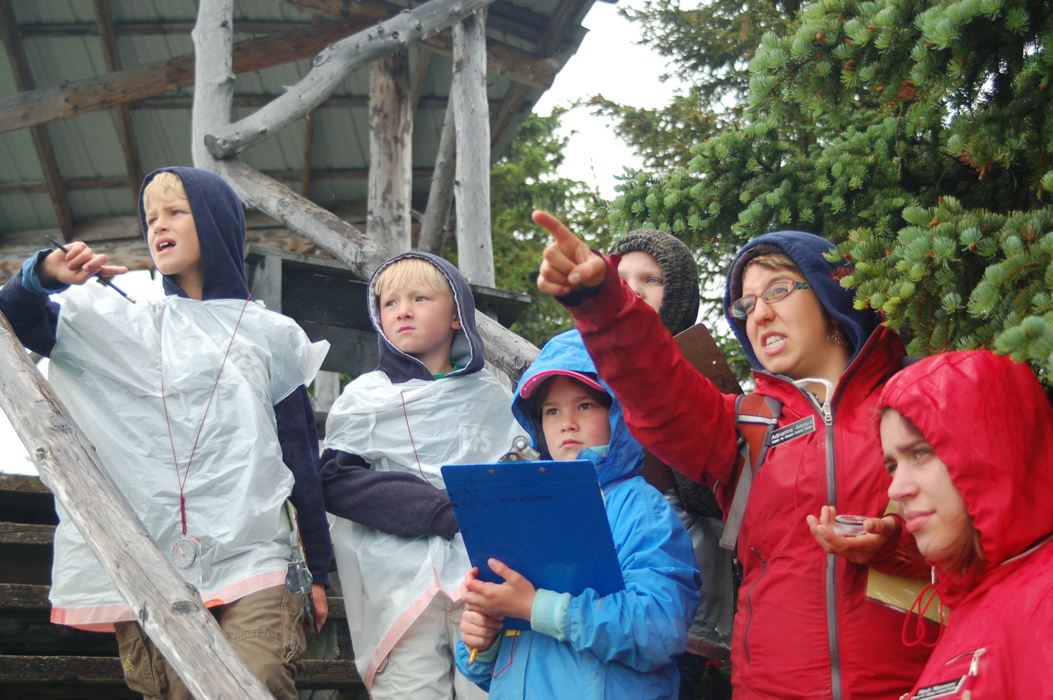 Adriana Amiya points to Grewingk Glacier on an orienteering walk last summer at the Carl Wynn Nature Center. Watching are, from left to right, Alex Gill, Troy Neese, Hannah Vance and assistant Heidi Neumann.-Photo by Michael Armstrong, Homer News