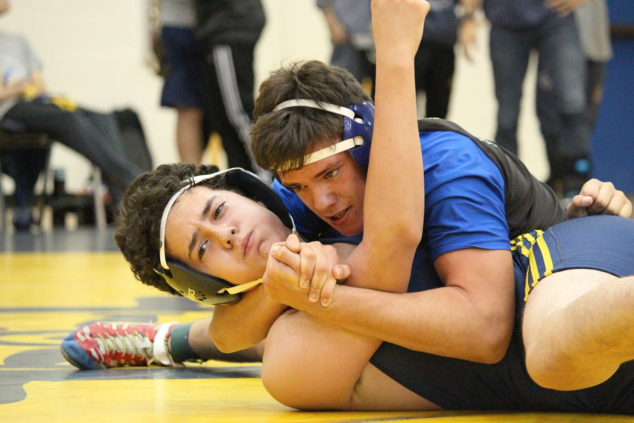 Kodiak’s Josh Nummer holds Homer’s Cayleb Diaz in place during their 171-pound weight class wrestling match Friday, Oct. 19, 2018 at Homer High School in Homer, Alaska. (Photo by Megan Pacer/Homer News)