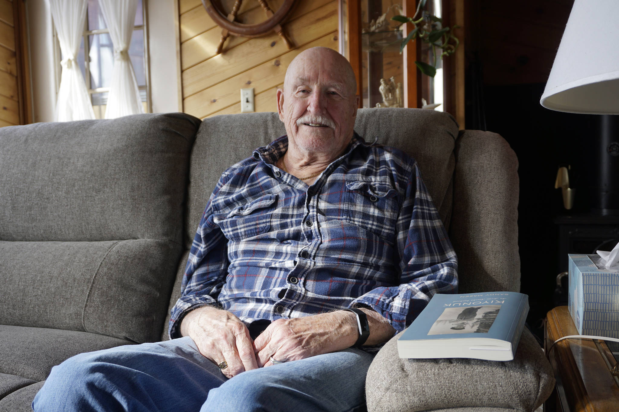 Sandy Mazen poses with a copy of his memoir, “Kiyonuk,” at his Homer, Alaska, home on April 22, 2019. (Photo by Michael Armstrong)