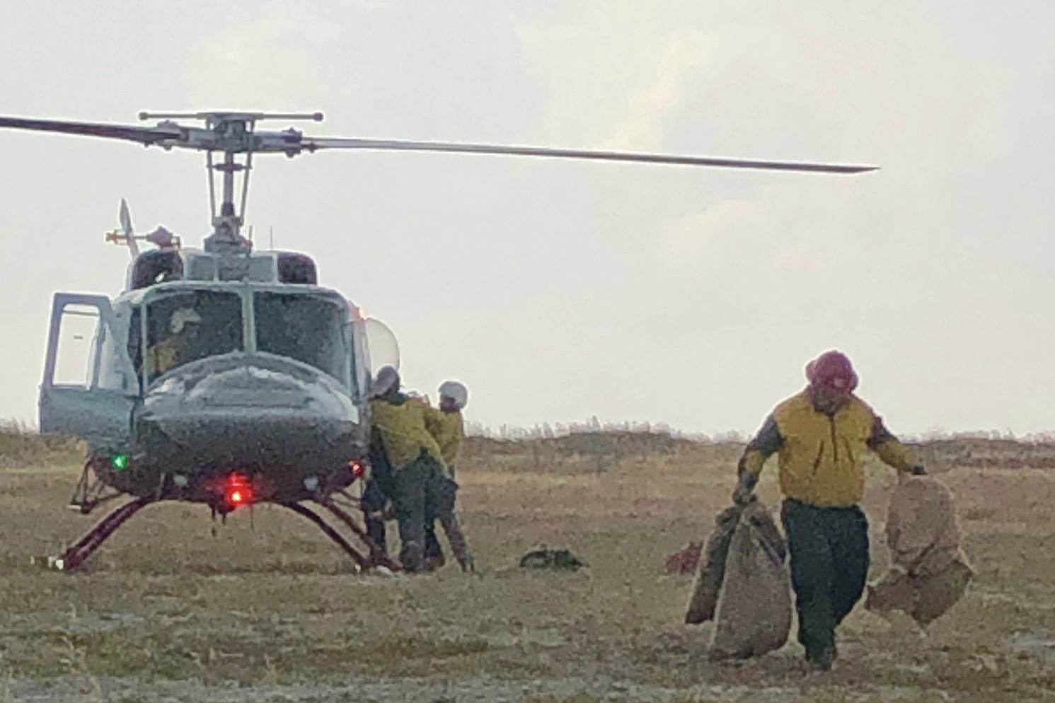 Firefighters unload supplies from a helicopter at the Caribou Lake Fire on Monday, Aug 26, 2019, northeast of Homer, Alaska. (Photo by Sarah Saarloos/Alaska Division of Forestry)