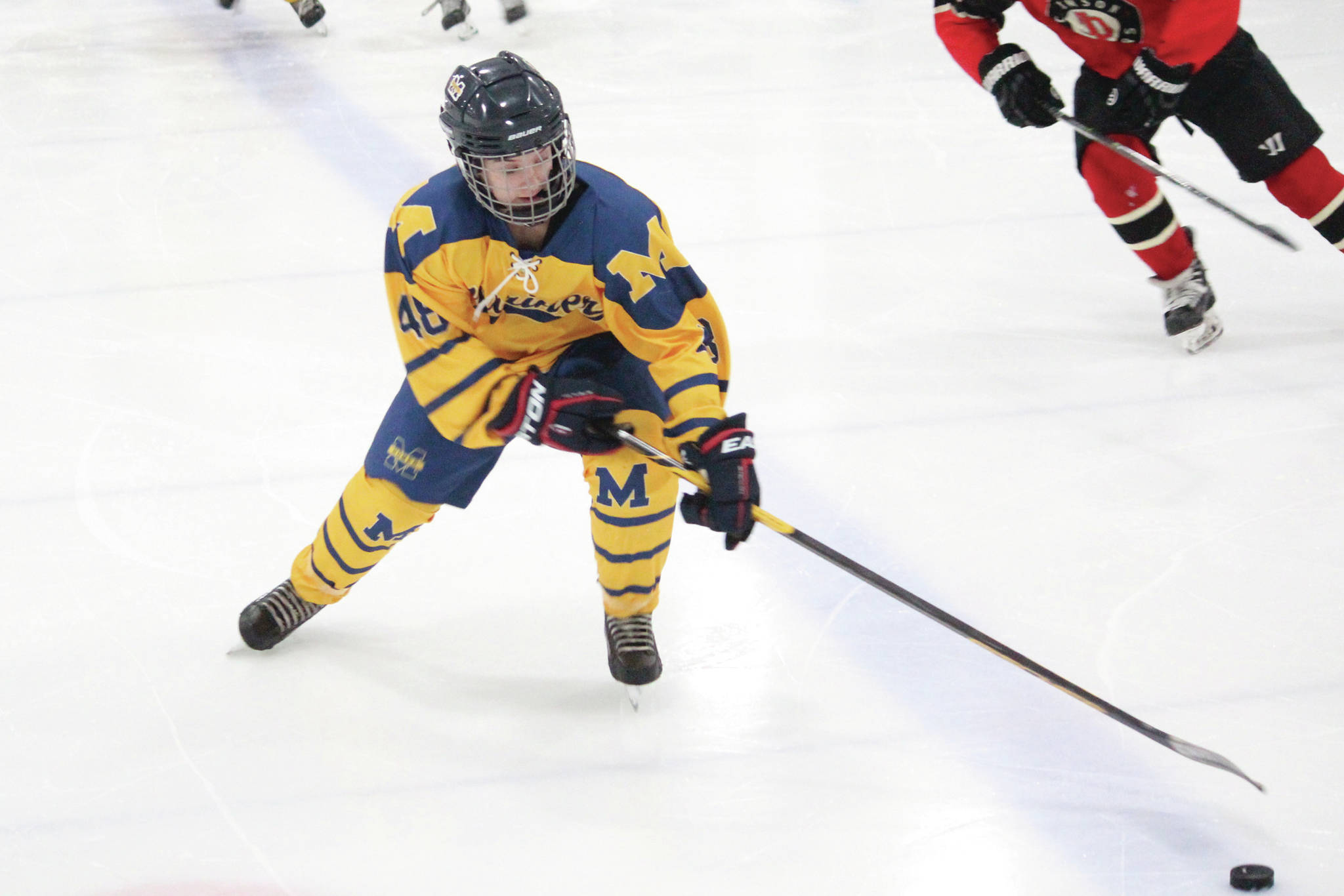 Homer’s Fiona Hatton reaches for the puck during a Friday, Dec. 6, 2019 hockey game against Juneau-Douglas High School at the Kevin Bell Arena in Homer, Alaska. (Photo by Megan Pacer/Homer News)