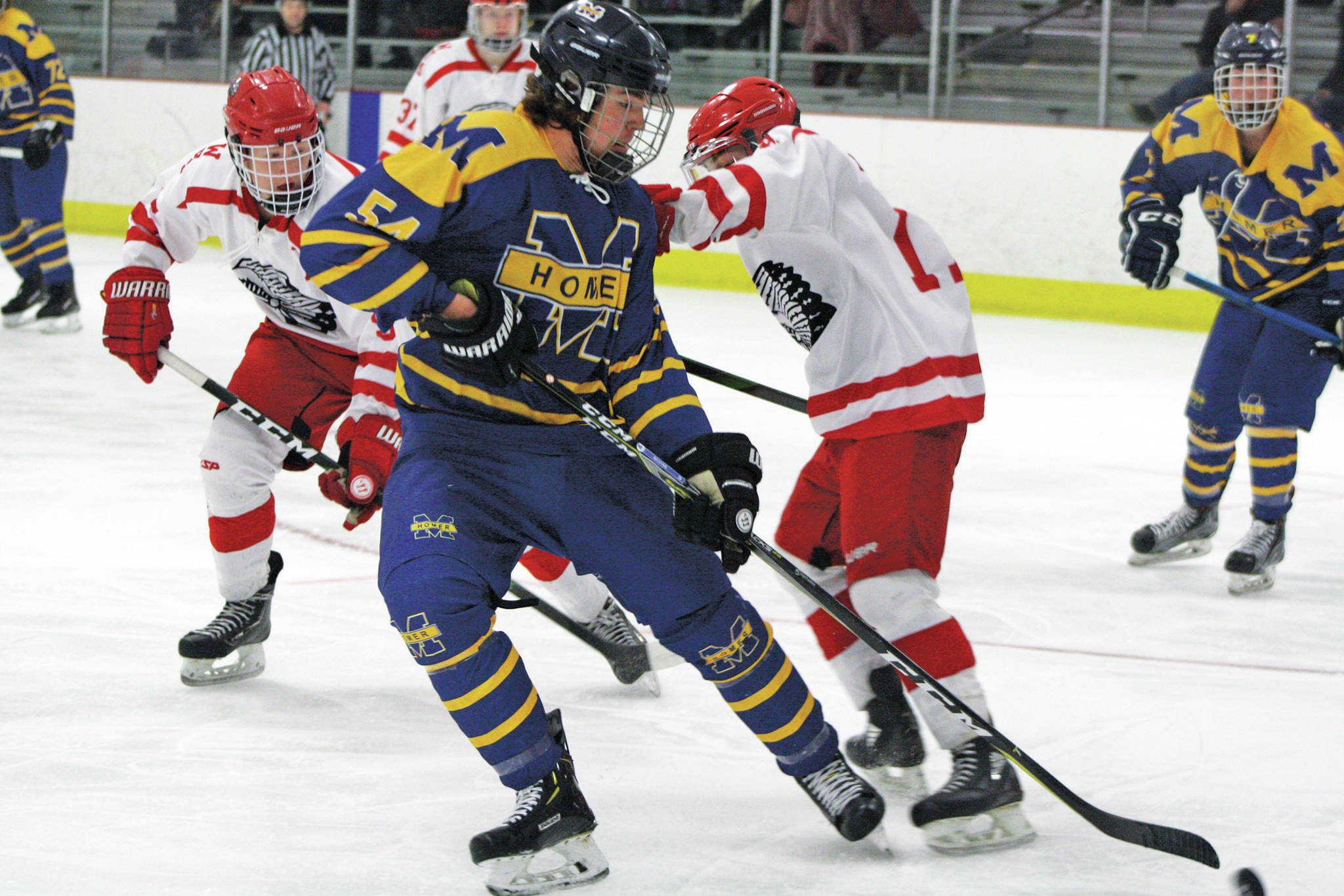 Homer’s Phinny Weston grabs the puck near the Wasilla net during a game against the Warriors Thursday, Jan. 23, 2020, in Wasilla, Alaska. (Photo by Jeremiah Bartz/Frontiersman)