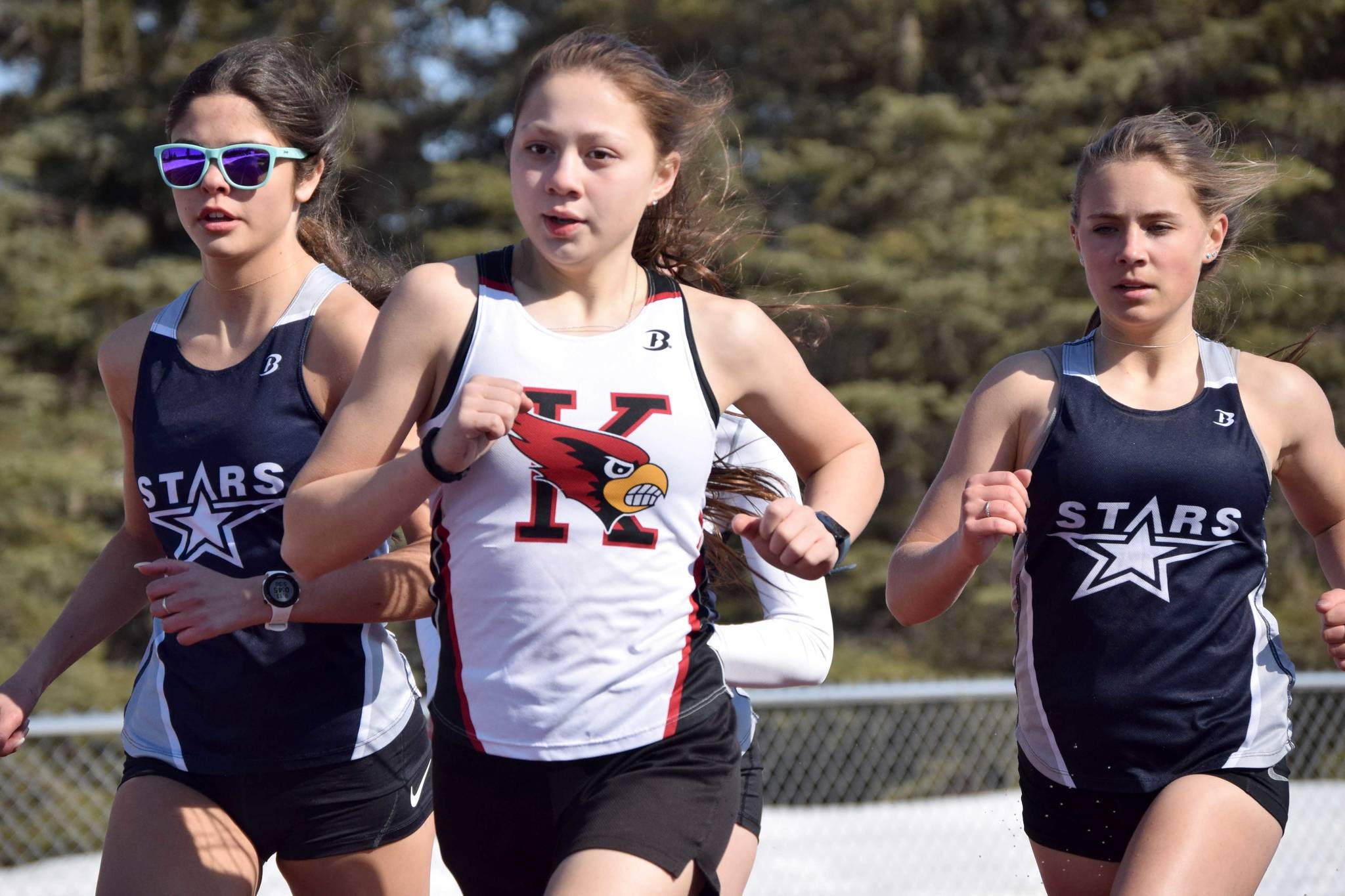 Kenai Central's Emilee Wilson leads Soldotna's Erika Arthur and Jordan Strausbaugh during the 800-meter run during a dual meet Friday, April 16, 2021, at Kenai Central High School in Kenai, Alaska. (Photo by Jeff Helminiak/Peninsula Clarion)