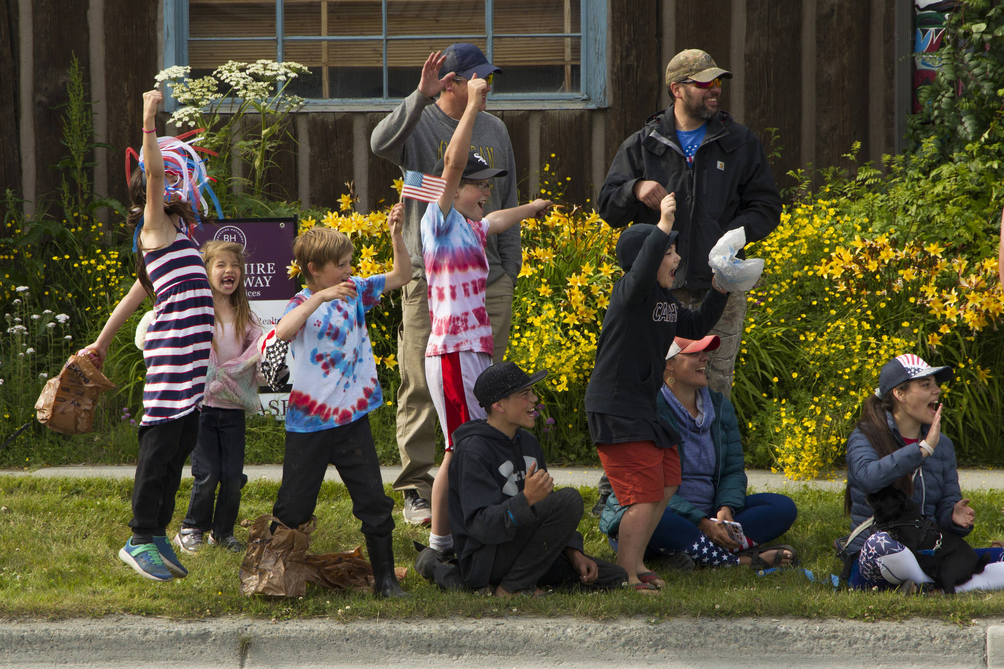 Children wait in anticipation for the 2021 Homer Fourth of July Parade to begin. As cars would drive by the crowd, the kids would chant “honk, honk, honk” and cheer when the passersby would comply. (Photo by Sarah Knapp/Homer News)