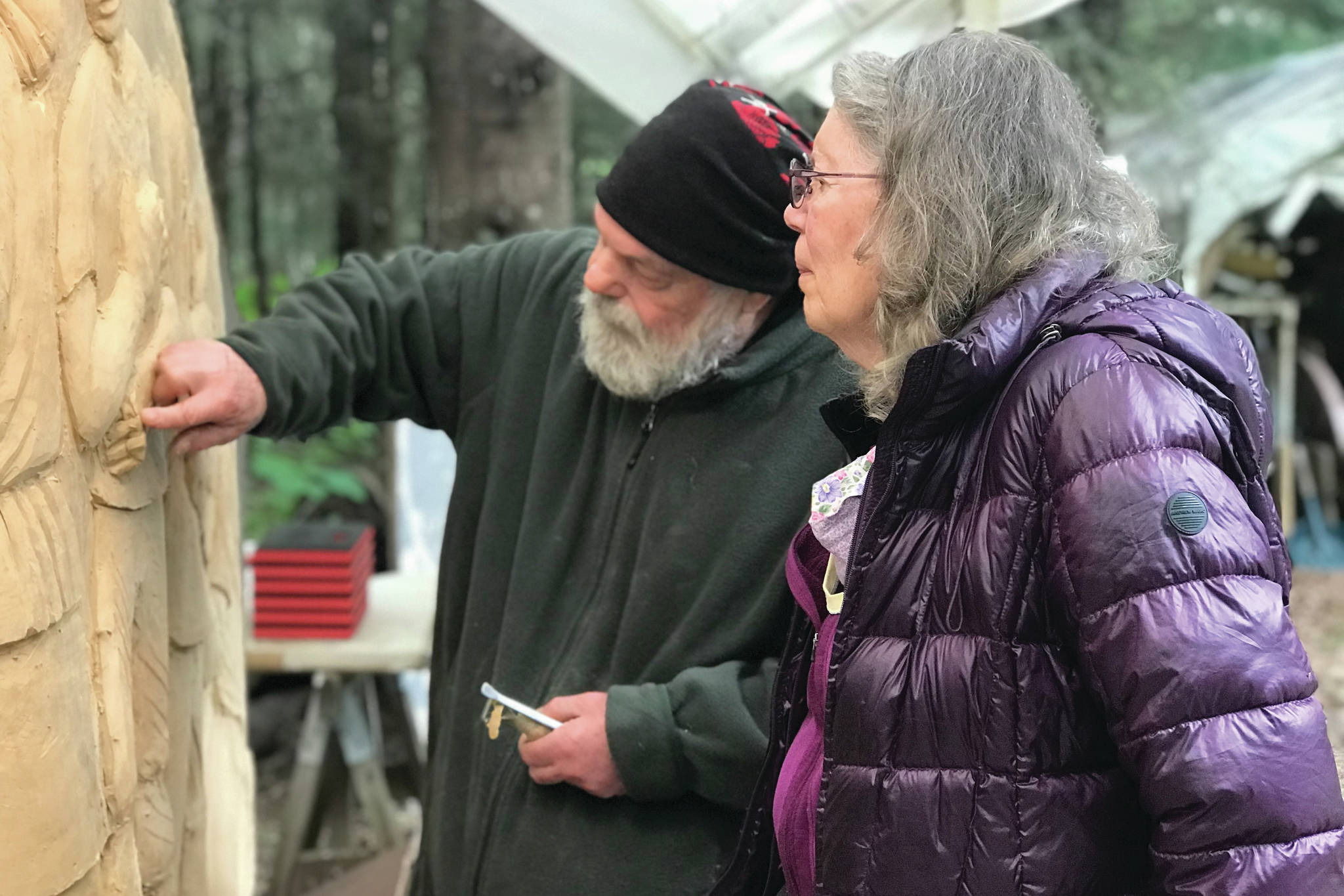 Sara Berg, right, talks with artist Brad Hughes, left, at Hughes' Homer, Alaska, studio in June 2021 about the Loved & Lost Memorial Bench project Berg and other family and friends of Anesha Murnane commissioned to honor Murnane and other missing woman and children. (Photo by Christina Whiting)