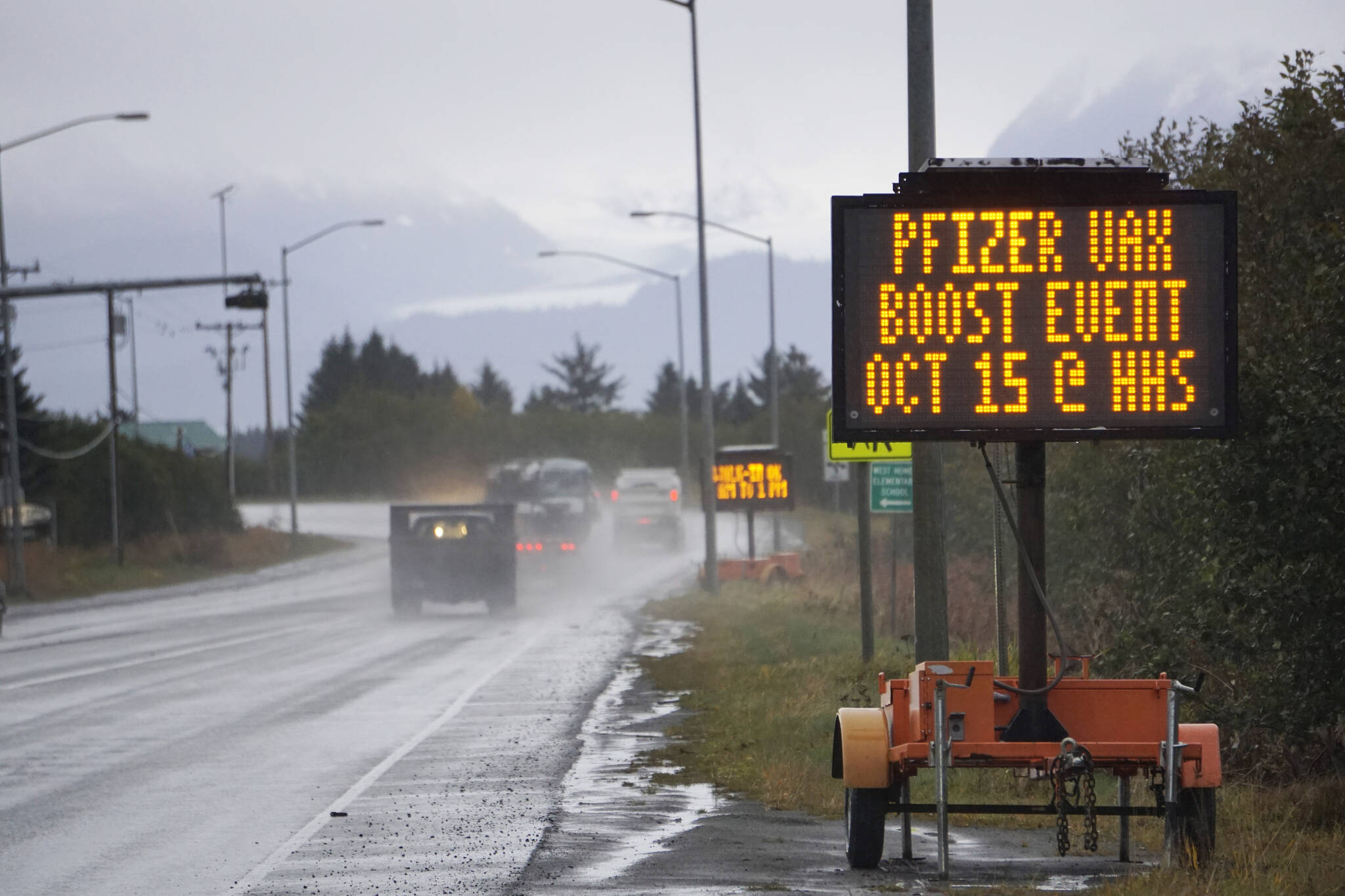 A portable sign on the Sterling Highway advertises a Pfizer COVID-19 vaccinaton booster clinic to be held 9 a.m. to 1 p.m. Friday, Oct. 15, 2021, at Homer High School in Homer, Alaska. A flu clinic also will be held at the same time at the high school. Appointments are encouraged for the Pfizer clinic. Visit www.sphosp.org for information. (Photo by Michael Armstrong/Homer News)