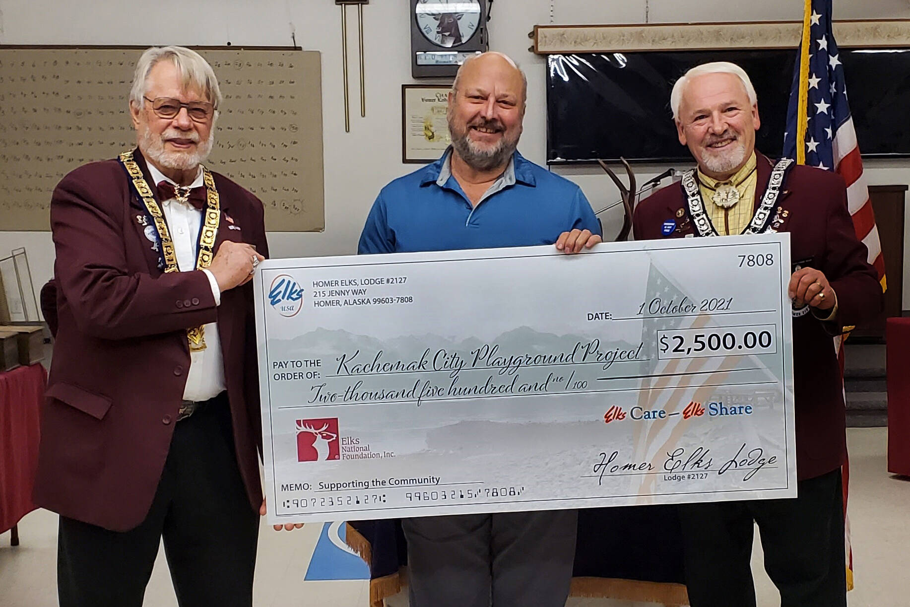 Homer Elks Lodge President David Spell, left, and Homer Elks Lodge Grant Coordinator Tom Stroozas, far right, present a $2,500 check to Kachemak City Council member Bill Fry, center, to help with construction of the Kachemak City Playground Project. (Photo provided)