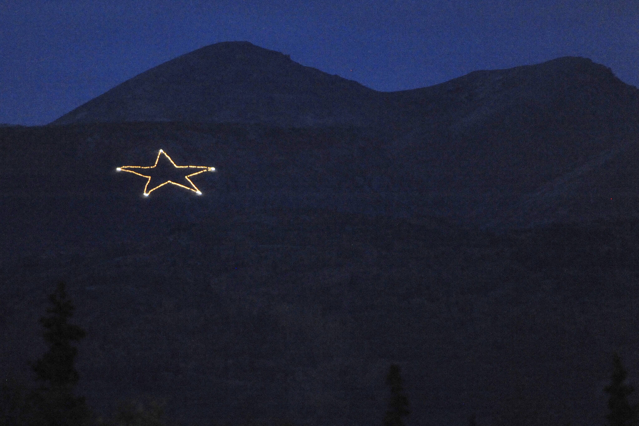 The Joint Base Elmendorf-Richardson star is Illuminated on the side of Mount Gordon Lyon on Wednesday, Sept. 11, 2019, just east of Anchorage, Alaska, in observation of the 18th anniversary of the terrorist attacks. A crew from the base went to light the 300-foot wide holiday star, but found that only half of the star’s 350 or so lights were working, the Anchorage Daily News reported. Airmen from the 773rd Civil Engineer Squadron Electrical Shop haven’t been able to figure out what was wrong and repair the lights, but they plan to work through the week, if necessary, base spokesperson Erin Eaton said. (Bill Roth/Anchorage Daily News via AP)