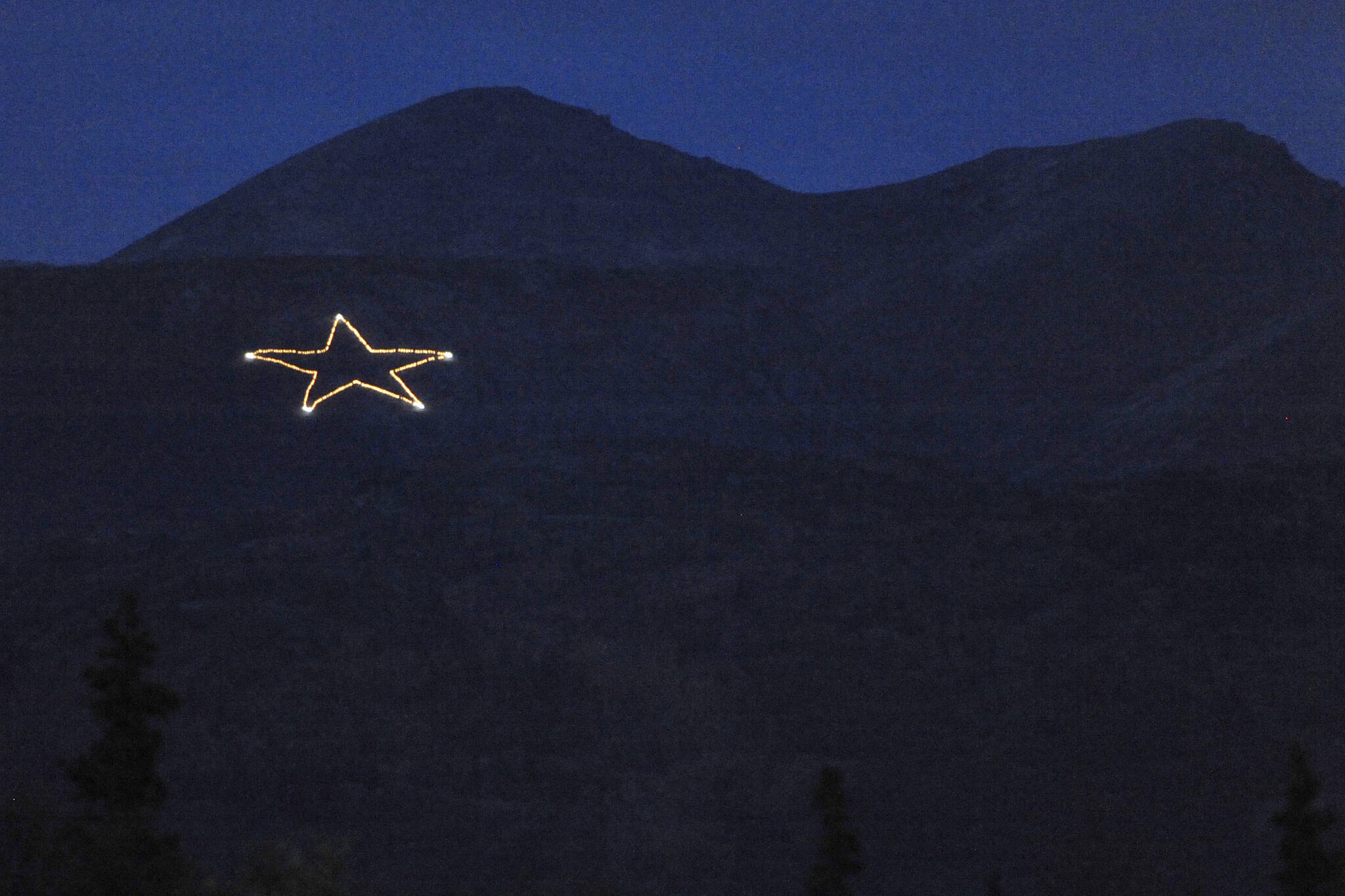 The Joint Base Elmendorf-Richardson star is Illuminated on the side of Mount Gordon Lyon on Wednesday, Sept. 11, 2019, just east of Anchorage, Alaska, in observation of the 18th anniversary of the terrorist attacks. A crew from the base went to light the 300-foot wide holiday star, but found that only half of the star’s 350 or so lights were working, the Anchorage Daily News reported. Airmen from the 773rd Civil Engineer Squadron Electrical Shop haven't been able to figure out what was wrong and repair the lights, but they plan to work through the week, if necessary, base spokesperson Erin Eaton said. (Bill Roth/Anchorage Daily News via AP)