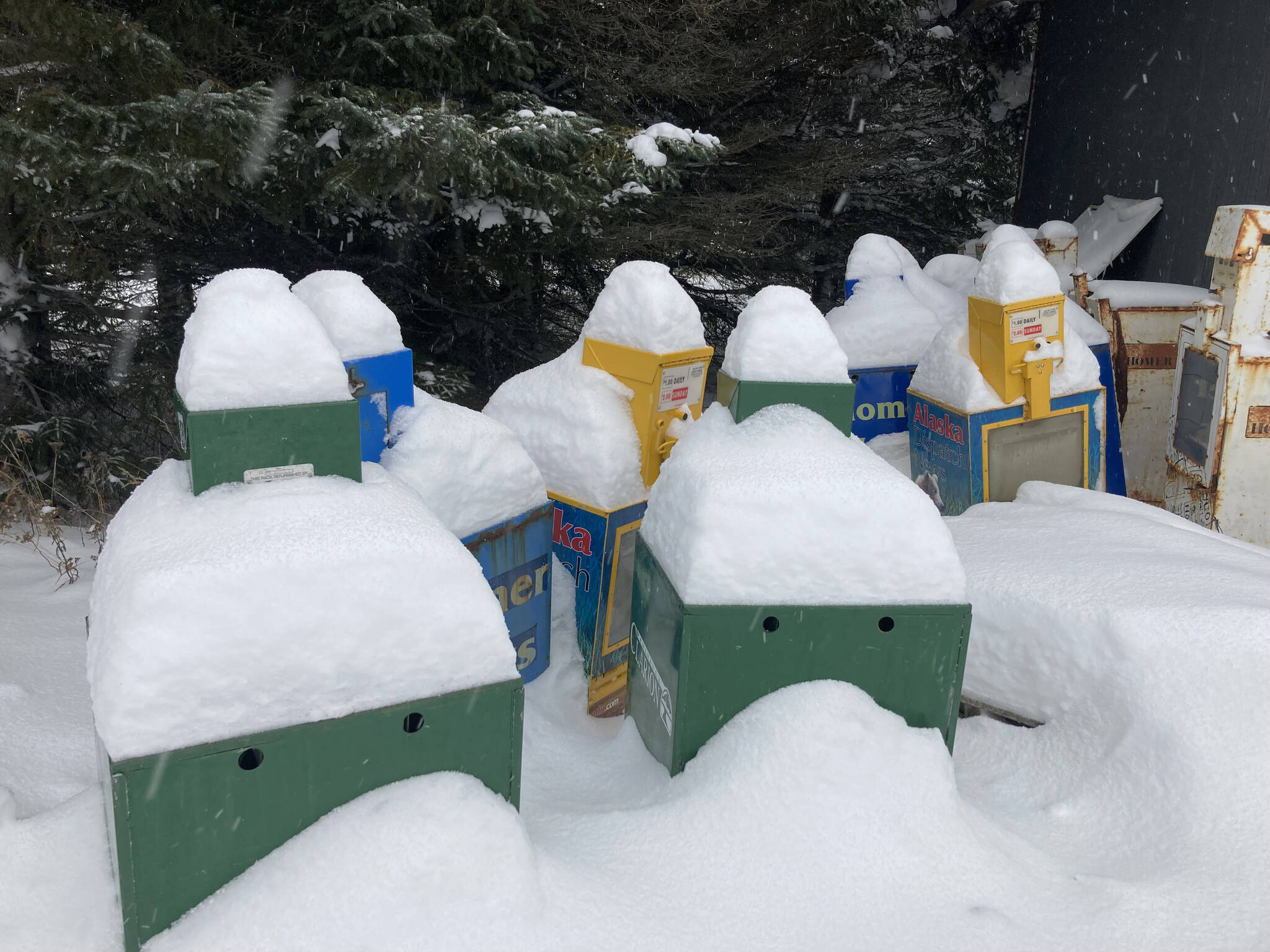 Snow covers surplus newspaper boxes at the Homer News earlier this mont, a reminder of how much snow fell in Homer before a post-Christmas warm spell melted the snow and turned streets icy. The weather forecast calls for snow and then cold, clear weather for the new year. (Photo by Michael Armstrong/Homer News)