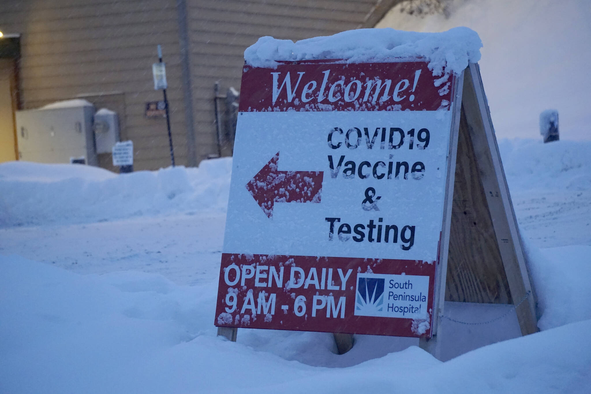 Snow covers the sign on Thursday, Dec. 9, 2021, at the Bartlett Street COVID-19 testing and vaccination clinic. (Photo by Michael Armstrong/Homer News)