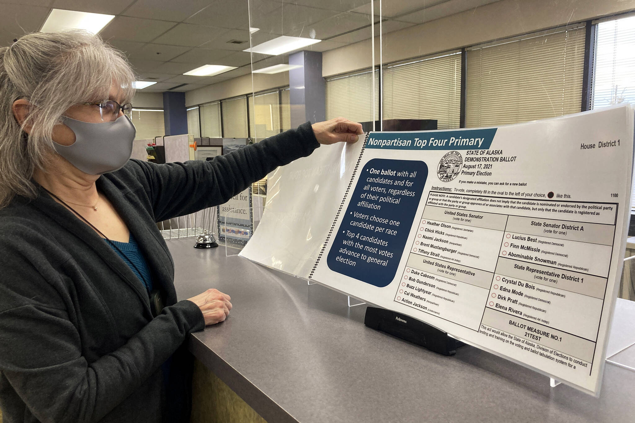 AP Photo / Mark Thiessen
Deborah Moody, an administrative clerk at the Alaska Division of Elections office in Anchorage, Alaska, looks at an oversized booklet explaining election changes in the state on Jan. 21, 2022. Alaska elections will be held for the first time this year under a voter-backed system that scraps party primaries and sends the top four vote-getters regardless of party to the general election, where ranked choice voting will be used to determine a winner. No other state conducts its elections with that same combination.