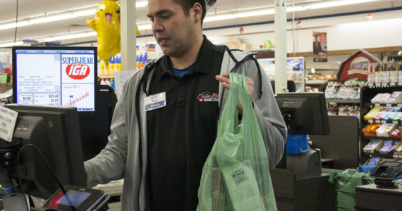 Brian Lauth, closing manager for Super Bear Supermarket IGA, bags groceries Thursday, Feb. 13, 2020. Next month, the Finance Committee for the City and Borough of Juneau will consider whether to exempt grocery purchases from the city's sales tax. (Ben Hohenstatt/Juneau Empire File)