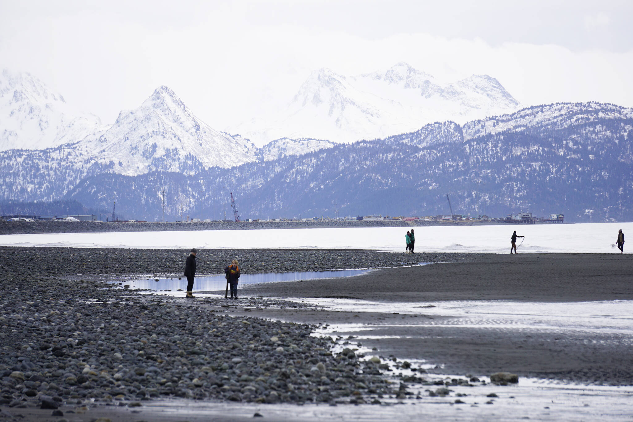 Beachcombers walk the Homer Spit on Monday, March 7, 2022, in Homer, Alaska. Despite the clouds, the beach was more crowded than usual because of spring break. (Photo by Michael Armstrong/Homer News)