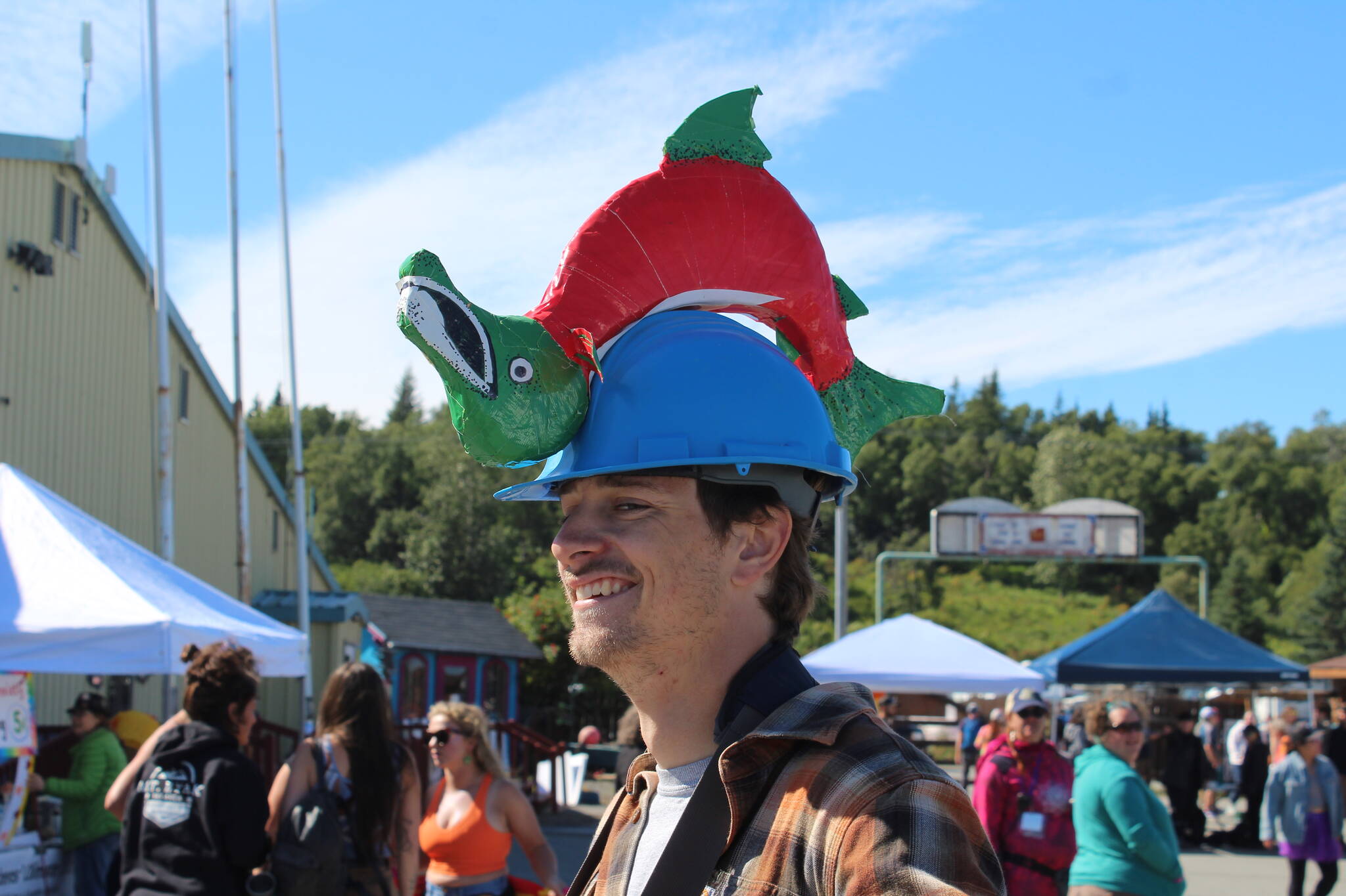 Volunteer Brandon Drzazgowski wears a salmon helmet while sharing trivia about salmon in Ninilchik, Alaska on Friday, August 5, 2022 for Salmonfest, an annual event that raises awareness about salmon-related causes. (Ashlyn O'Hara/Peninsula Clarion)