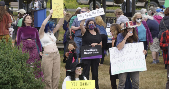 People hold signs at the “Women’s March: Bans Off Our Bodies” protest on Saturday, July 9 at WKFL Park . (Photo by Michael Armstrong/Homer News)