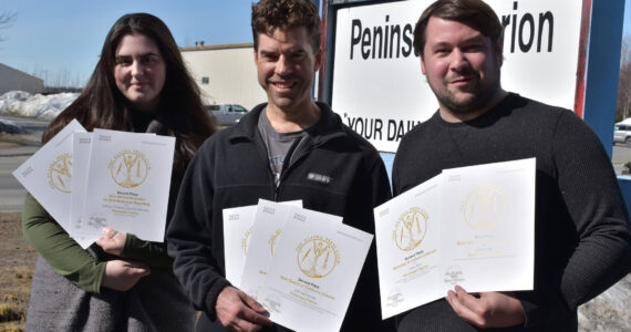 Kenai Peninsula reporter Ashlyn O’Hara, Sports Editor Jeff Helminiak and reporter Jake Dye pose with their 2022 Alaska Press Club awards, Monday, April 24, 2023, in Kenai, Alaska. (Photo by Erin Thompson/Peninsula Clarion)