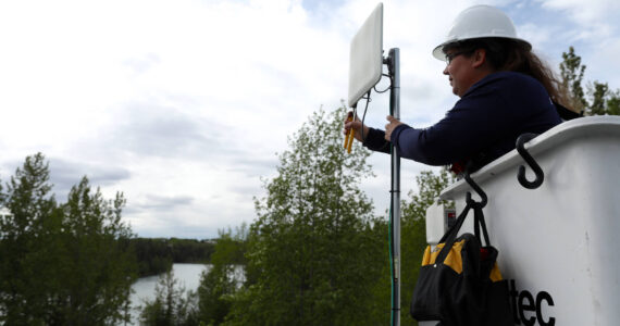 An Alaska Communications technician installs a customer premise device to a home in Sterling, Alaska. This device communicates with a nearby tower, serving the customer with a high-speed internet connection. Photo courtesy of Alaska Communications