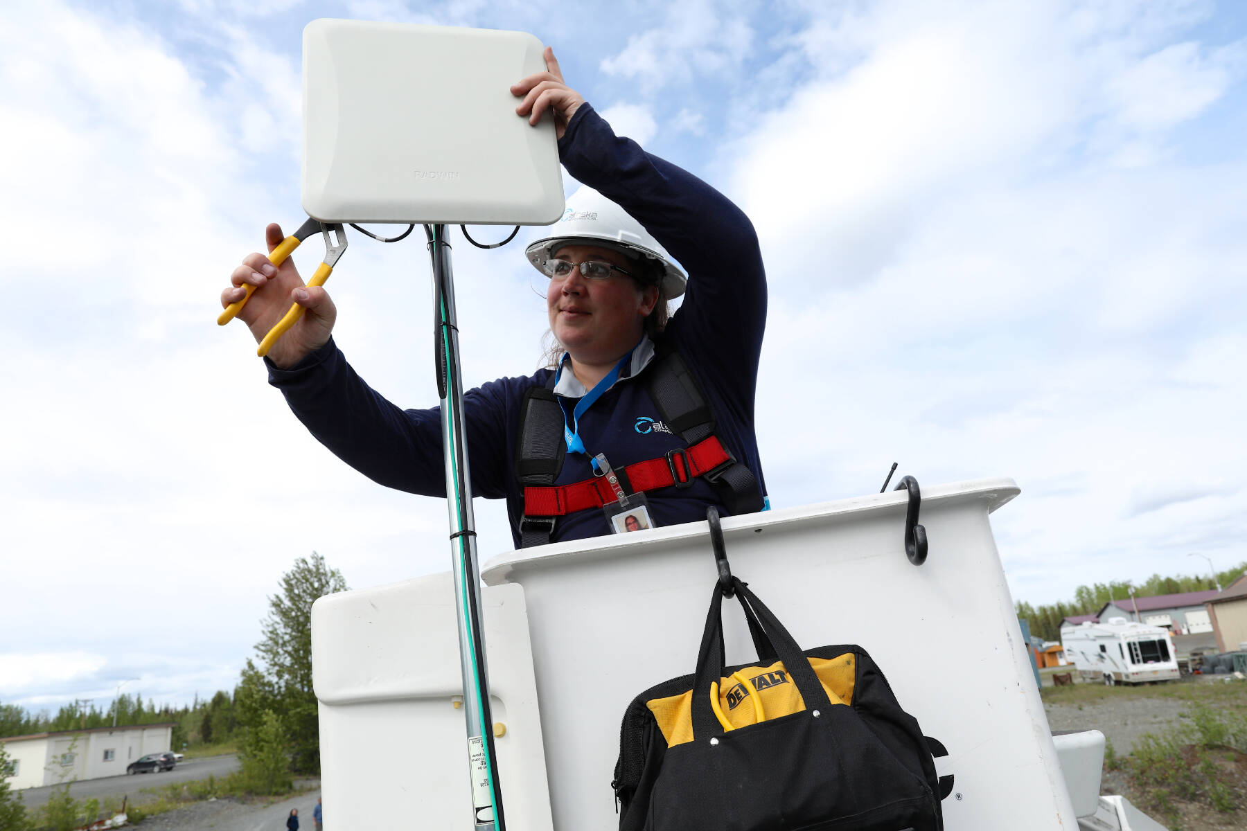 An Alaska Communications technician installs a customer premise device to a home in Sterling, Alaska. This device communicates with a nearby tower, serving the customer with a high-speed internet connection. Photo courtesy of Alaska Communications