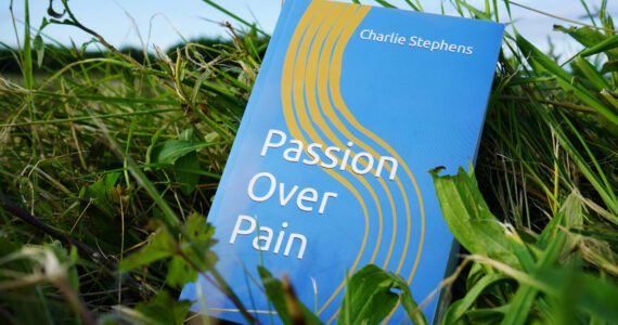 A copy of Charlie Stephens' "Passion Over Pain" rests in grass on Wednesday, July 12, 2023, in Soldotna, Alaska. (Jake Dye/Peninsula Clarion)