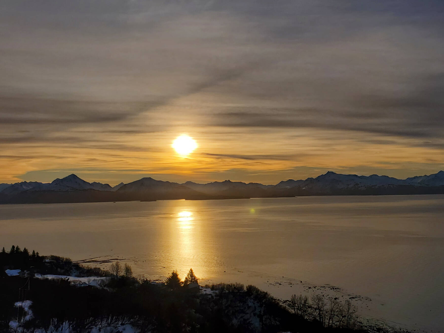 The late morning sun rises over the mountains across Kachemak Bay on Tuesday, Jan. 16, 2024 in Homer, Alaska. (Delcenia Cosman/Homer News)