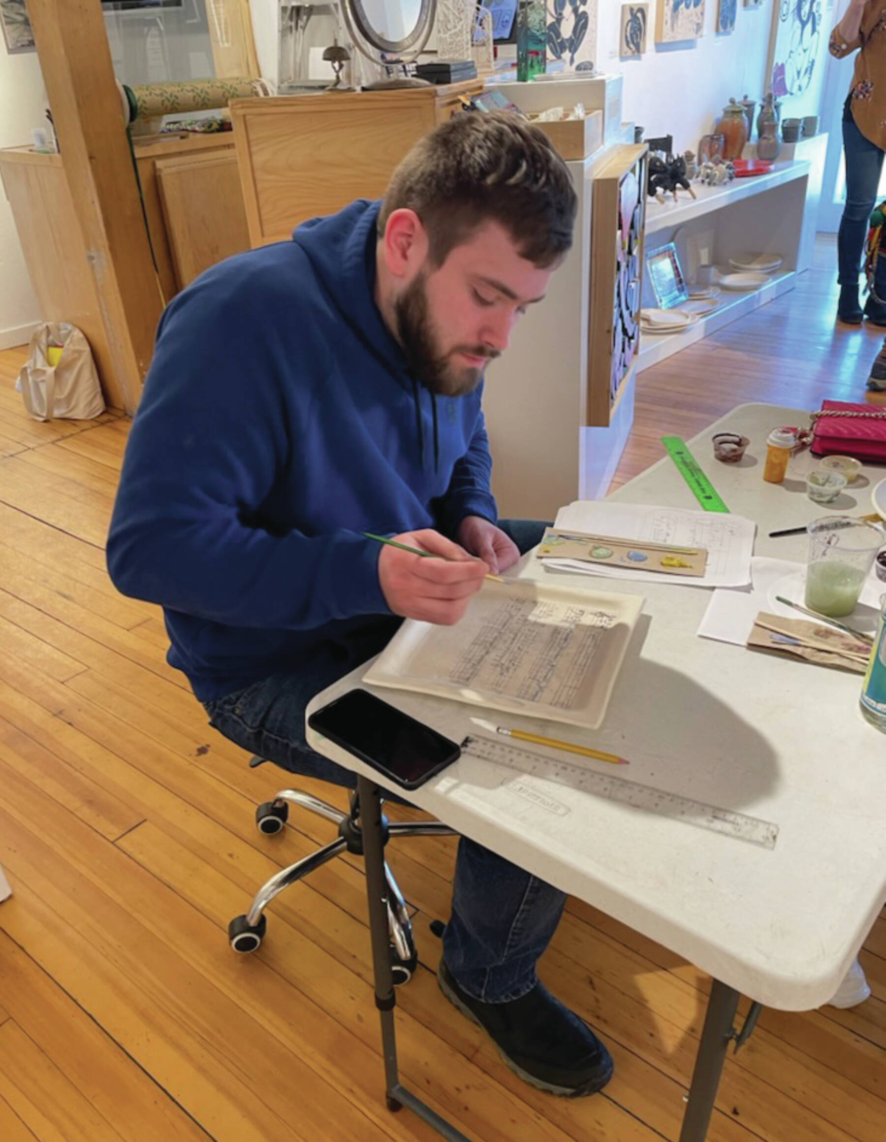 Mitchell Hedrick begins to add paint to his music-themed plate at Bunnell’s plate workshop on Saturday, March 2<ins>, 2024</ins> at the Bunnell Street Arts Center gallery in Homer<ins>, Alaska</ins>. (Emilie Springer/Homer News)