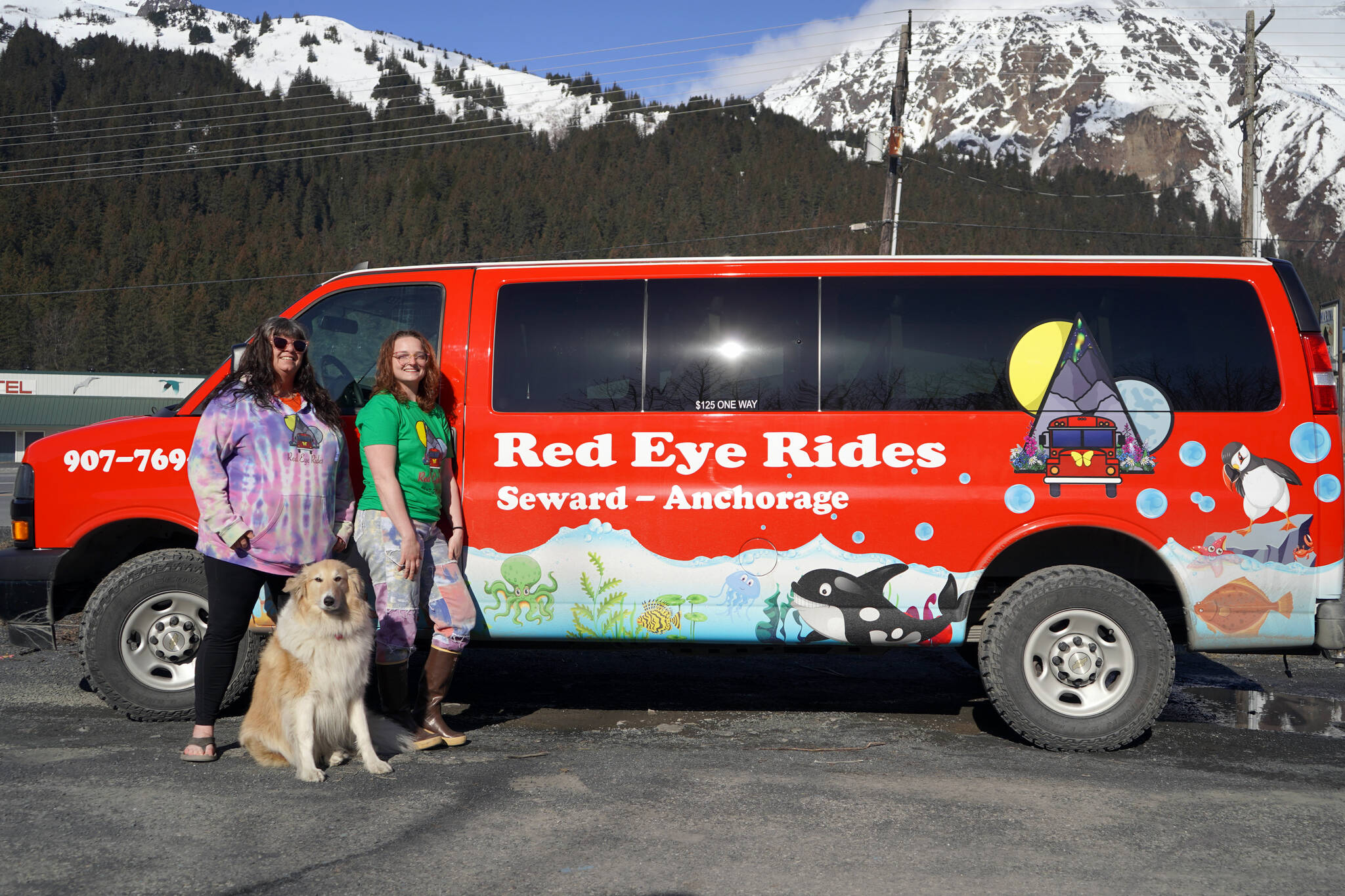 Angel Patterson-Moe and Natalie Norris stand in front of one of their Red Eye Rides vehicles in Seward, Alaska, on Wednesday, April 24, 2024. (Jake Dye/Peninsula Clarion)